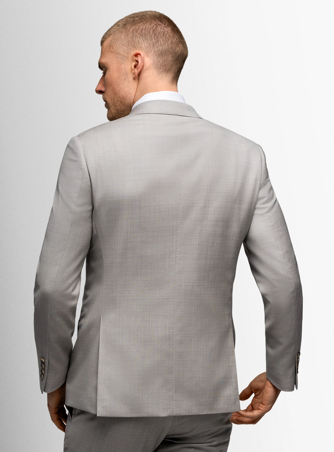 Man wearing a gray suit jacket on a plain background