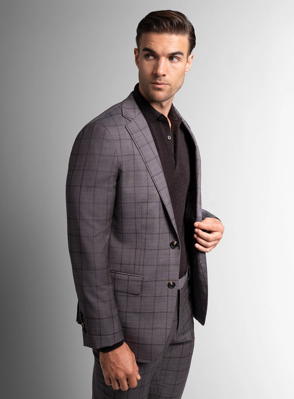 Man wearing a gray checkered suit against a gray background