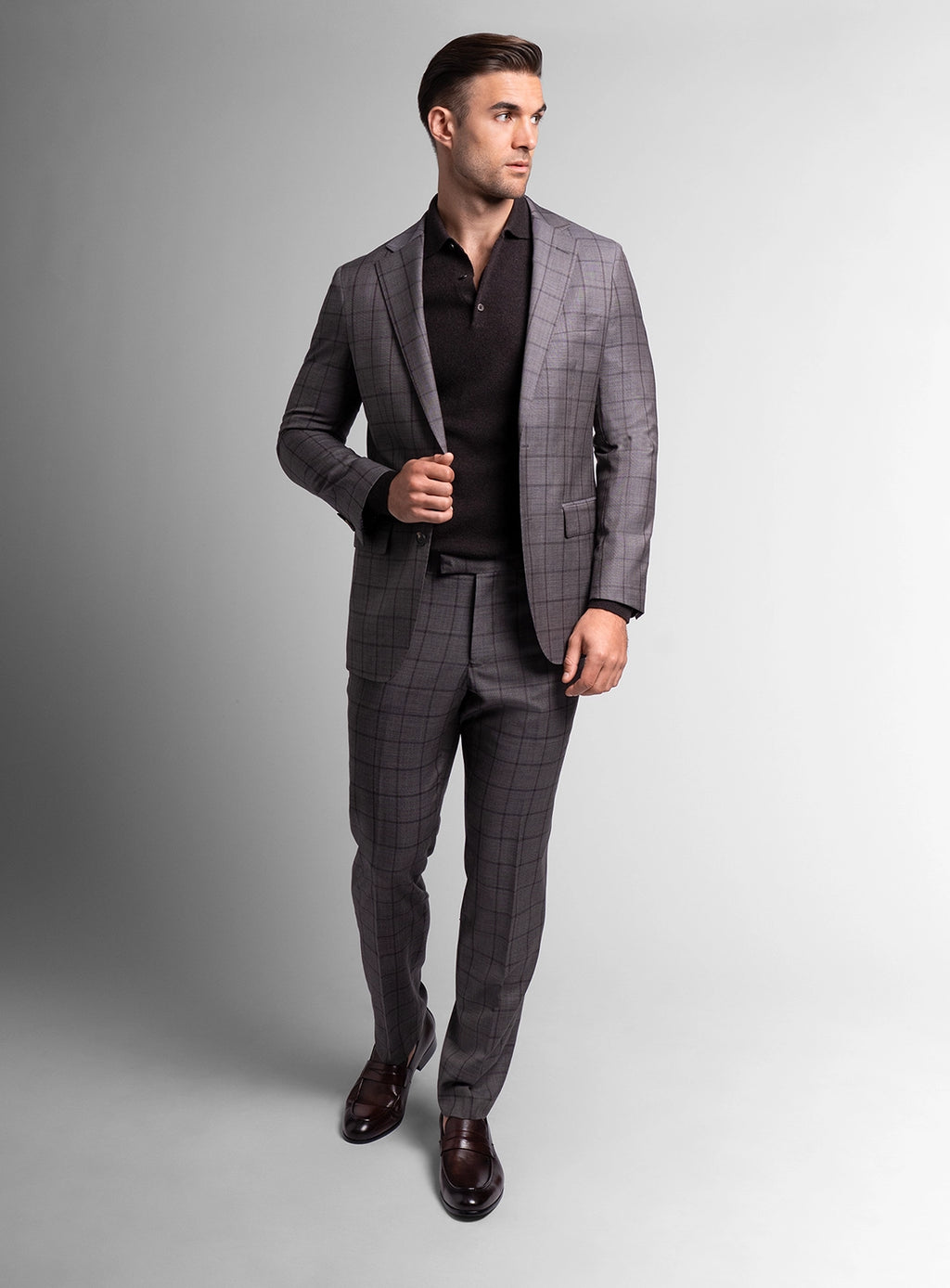 Man wearing a gray checkered suit on a plain background