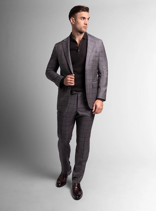 Man wearing a gray checkered suit on a plain background