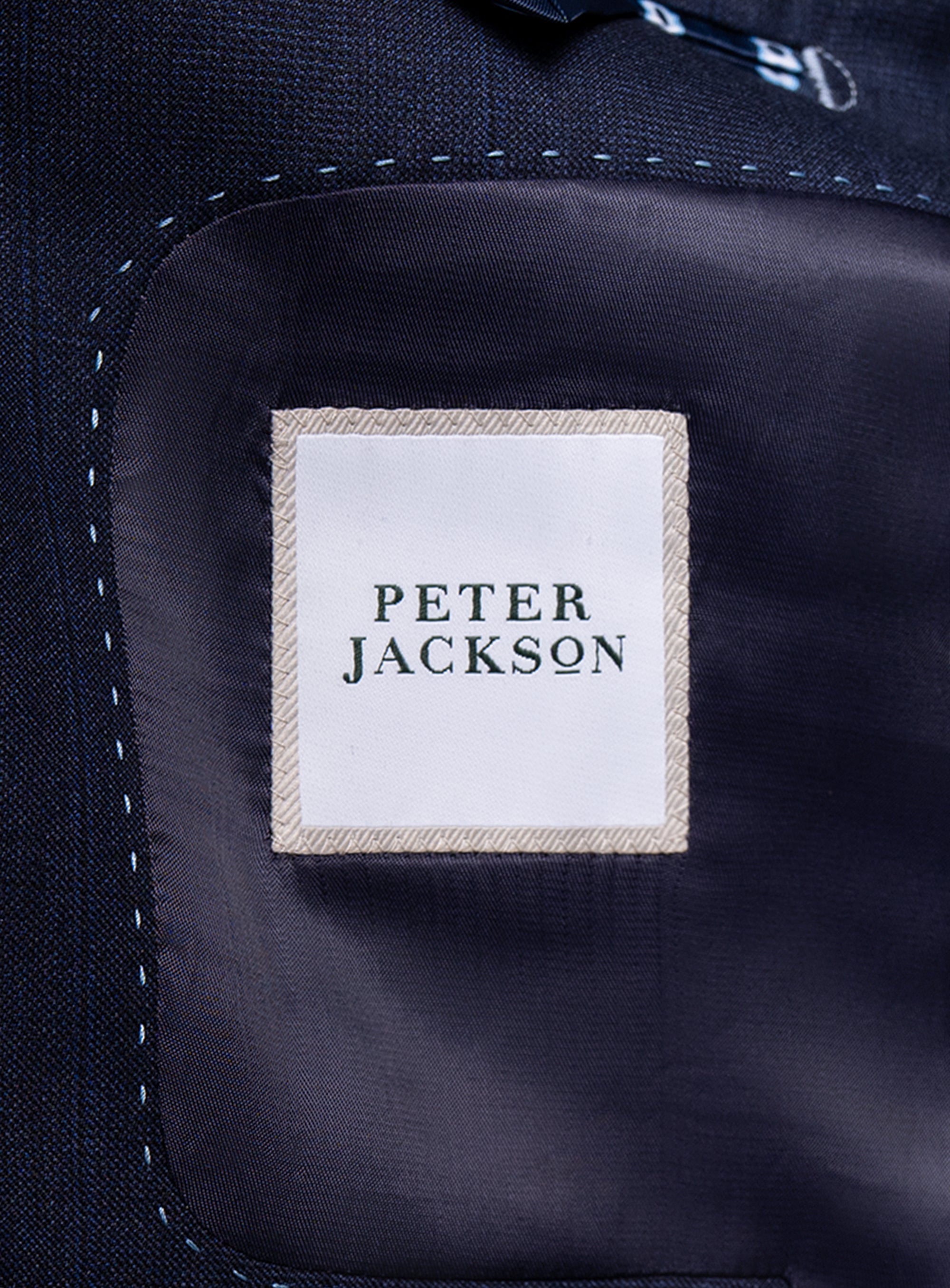 Navy shirt with 'Peter Jackson' label on a dark background