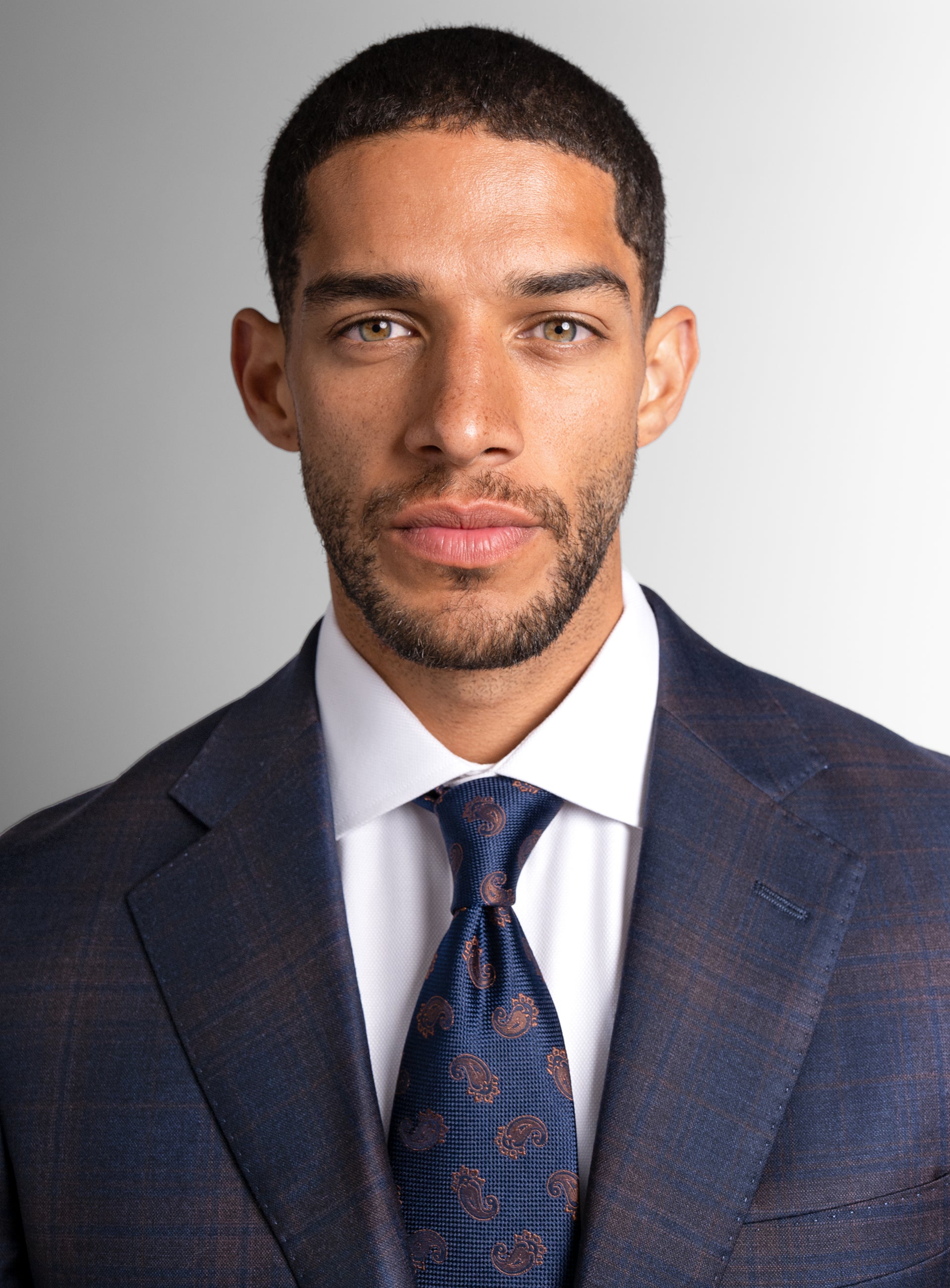 Close-up of a man wearing the Fredo Bronze Plaid Navy Suit