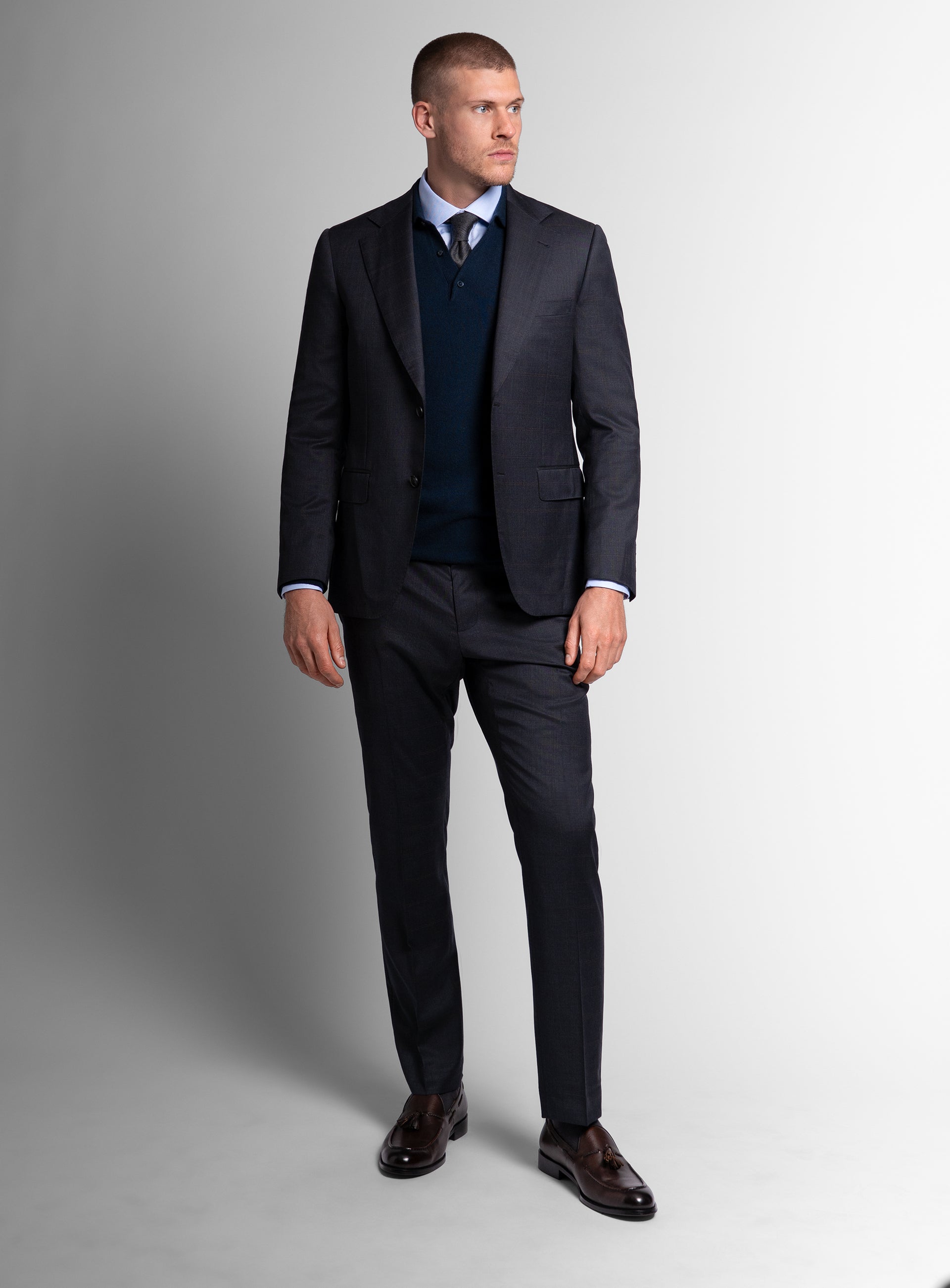 Man looking to his side while wearing the Volterra Navy Check Suit