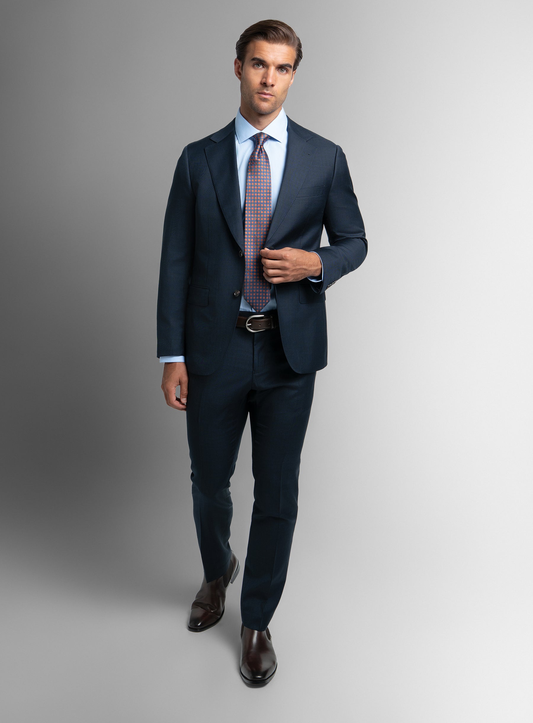 A man taking a step while wearing the Vasquez Textured Navy Suit