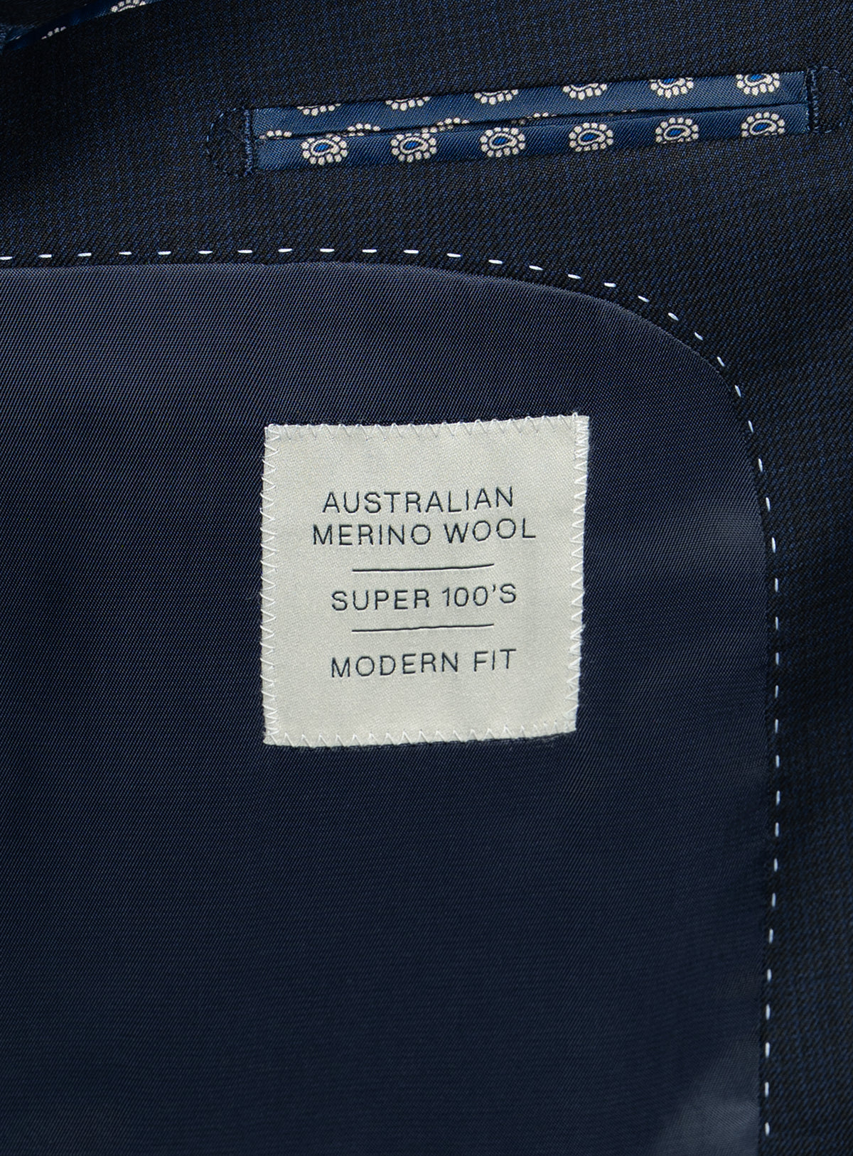 A label that says "Australian Merino Wool - Super 100's - Modern Fit" on the Vasquez Textured Navy Suit
