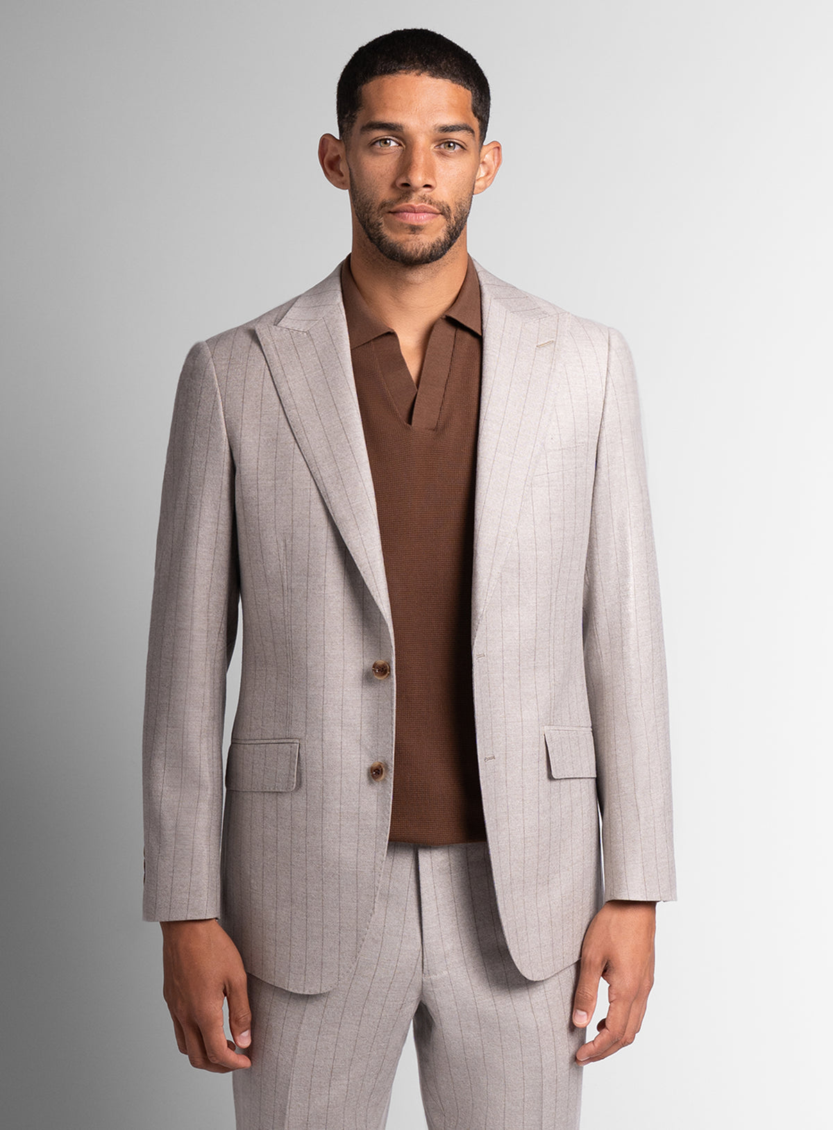 Man wearing white suit with brown shirt