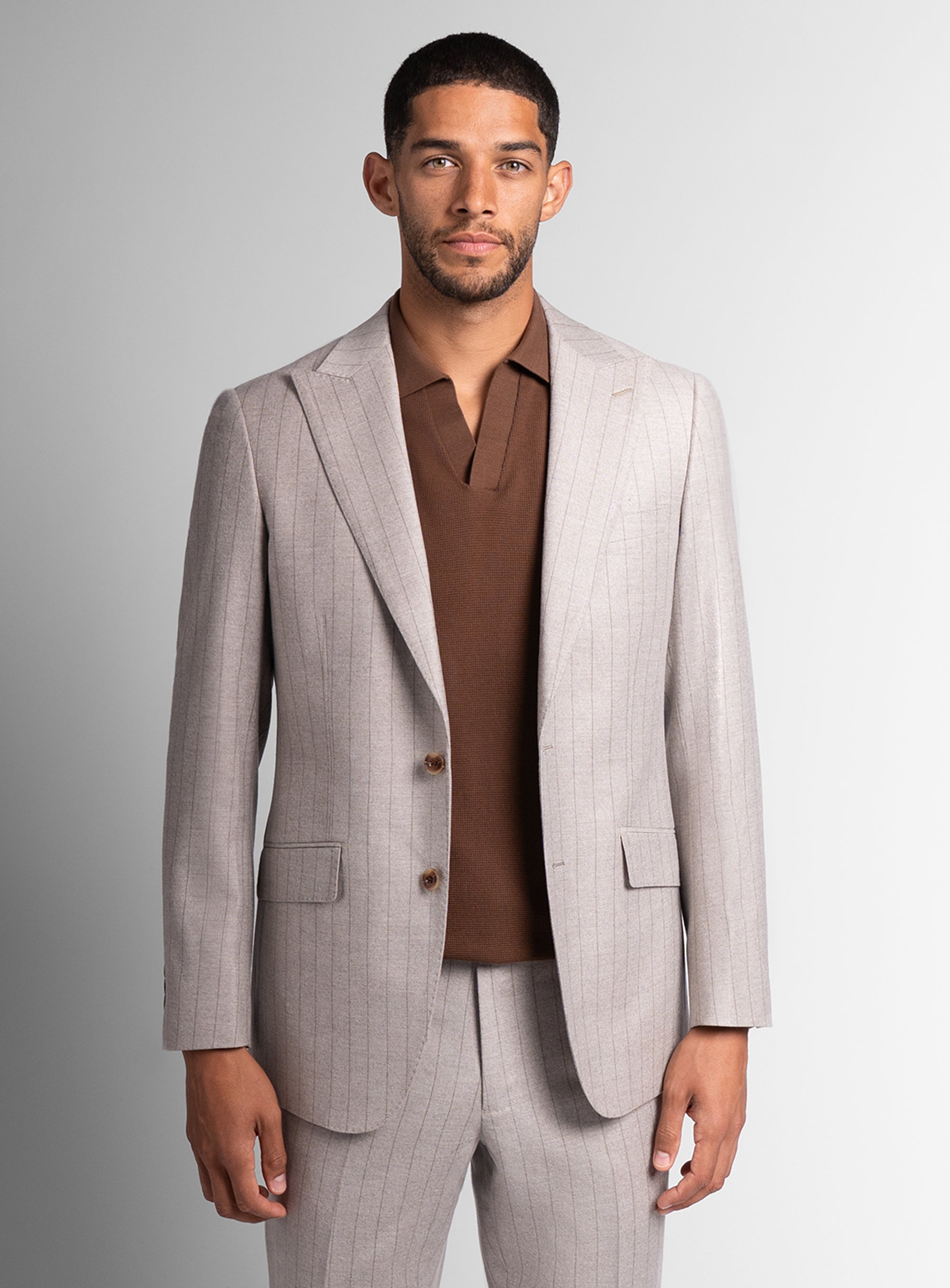 Man wearing white suit with brown shirt