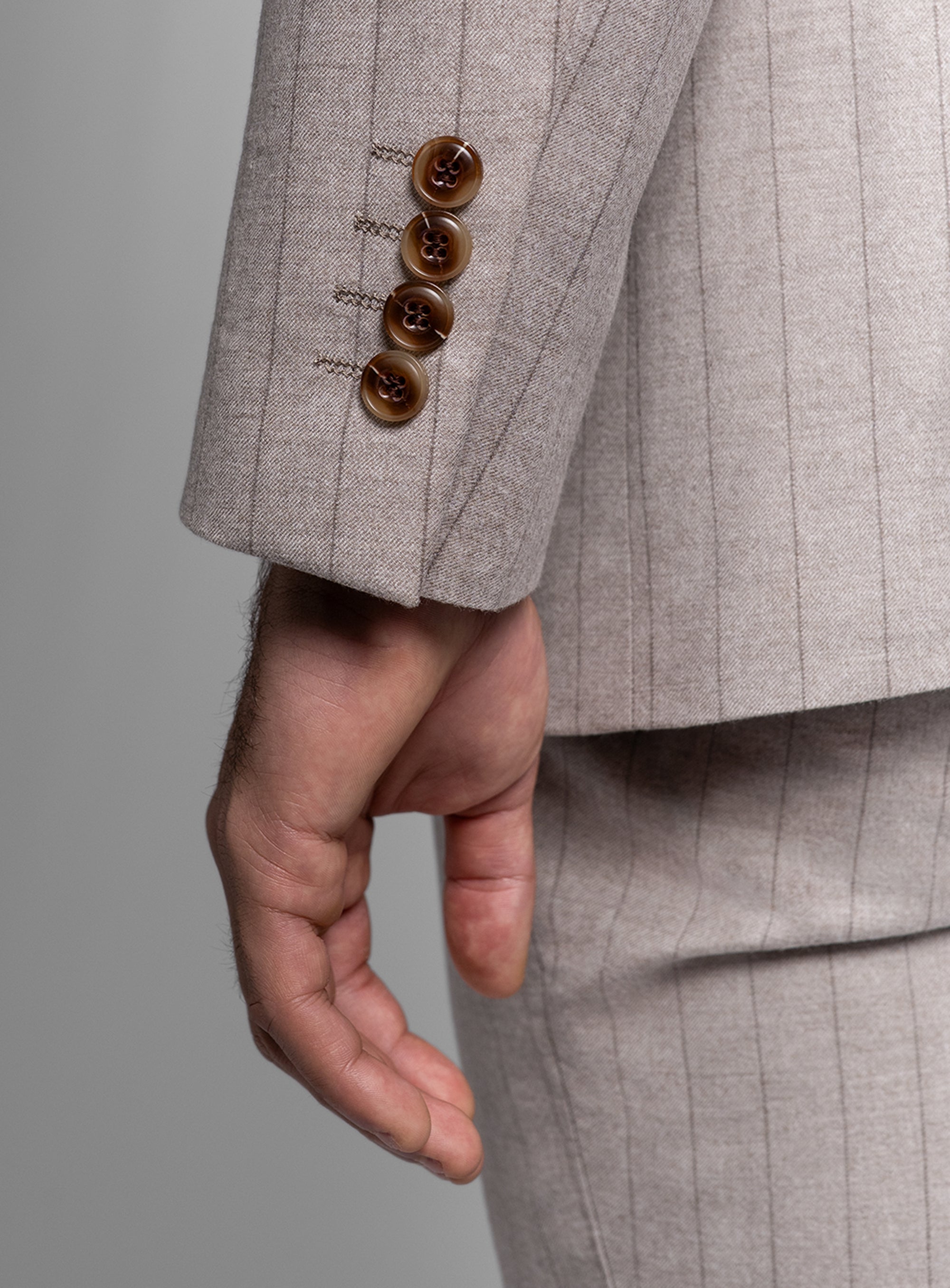 White suit with brown buttons on a gray background