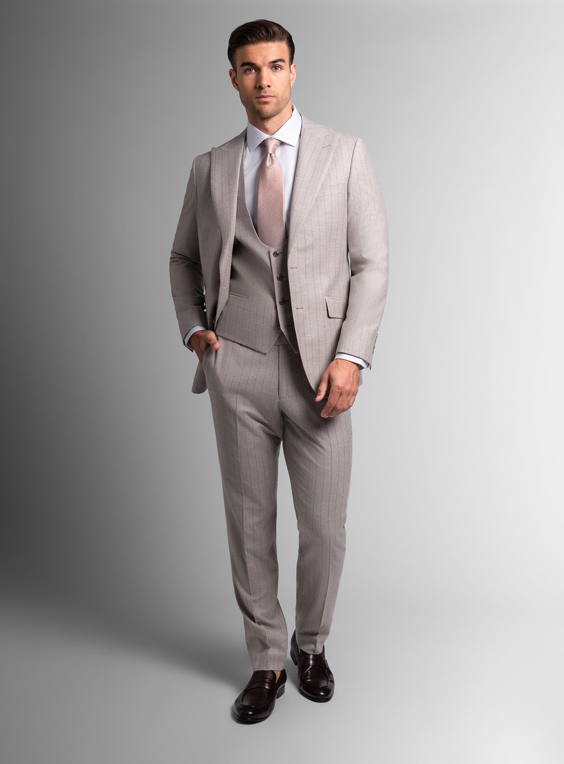 Man wearing white suit with white shirt and pink tie