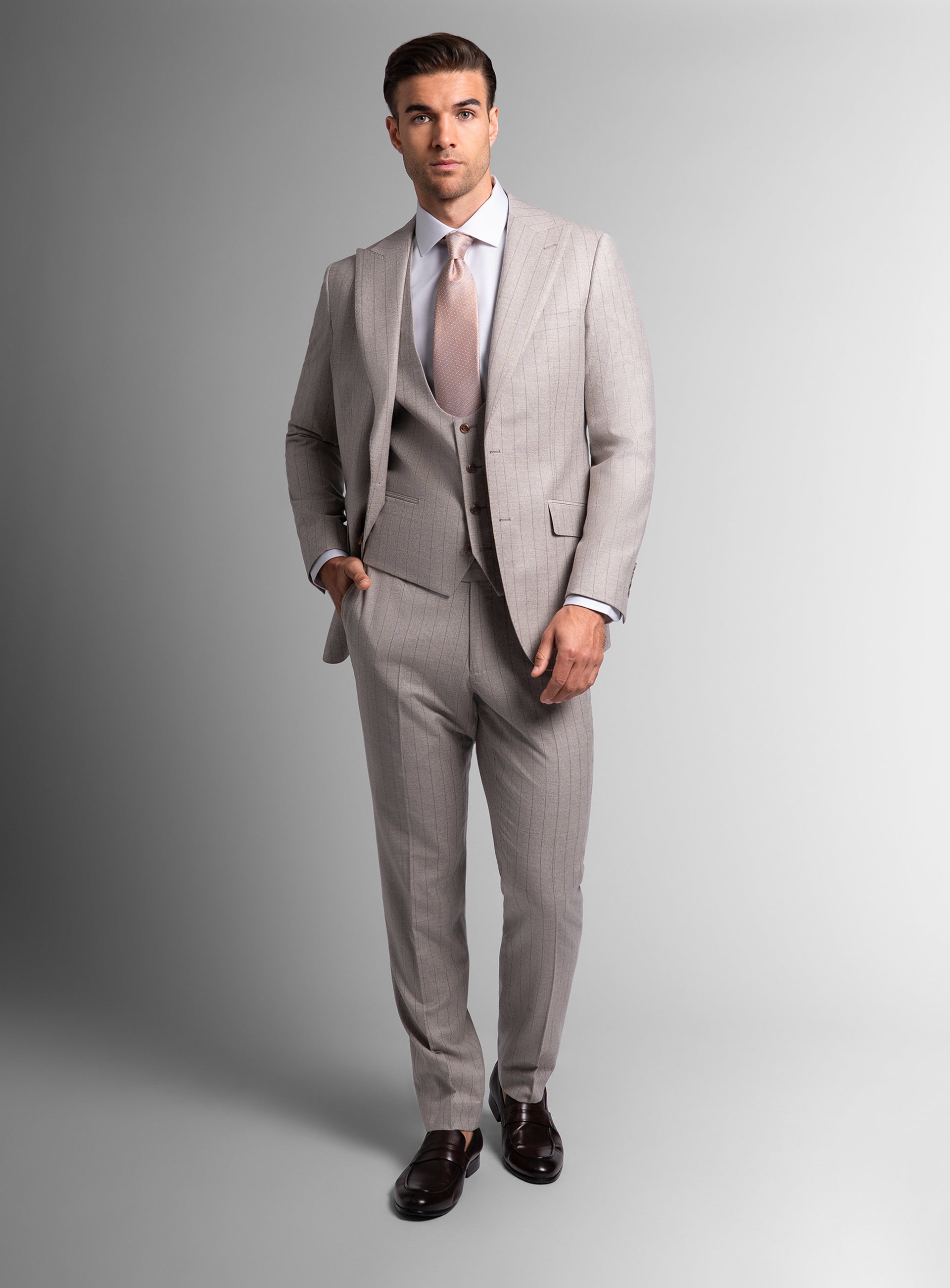 Man wearing white suit with white shirt and pink tie