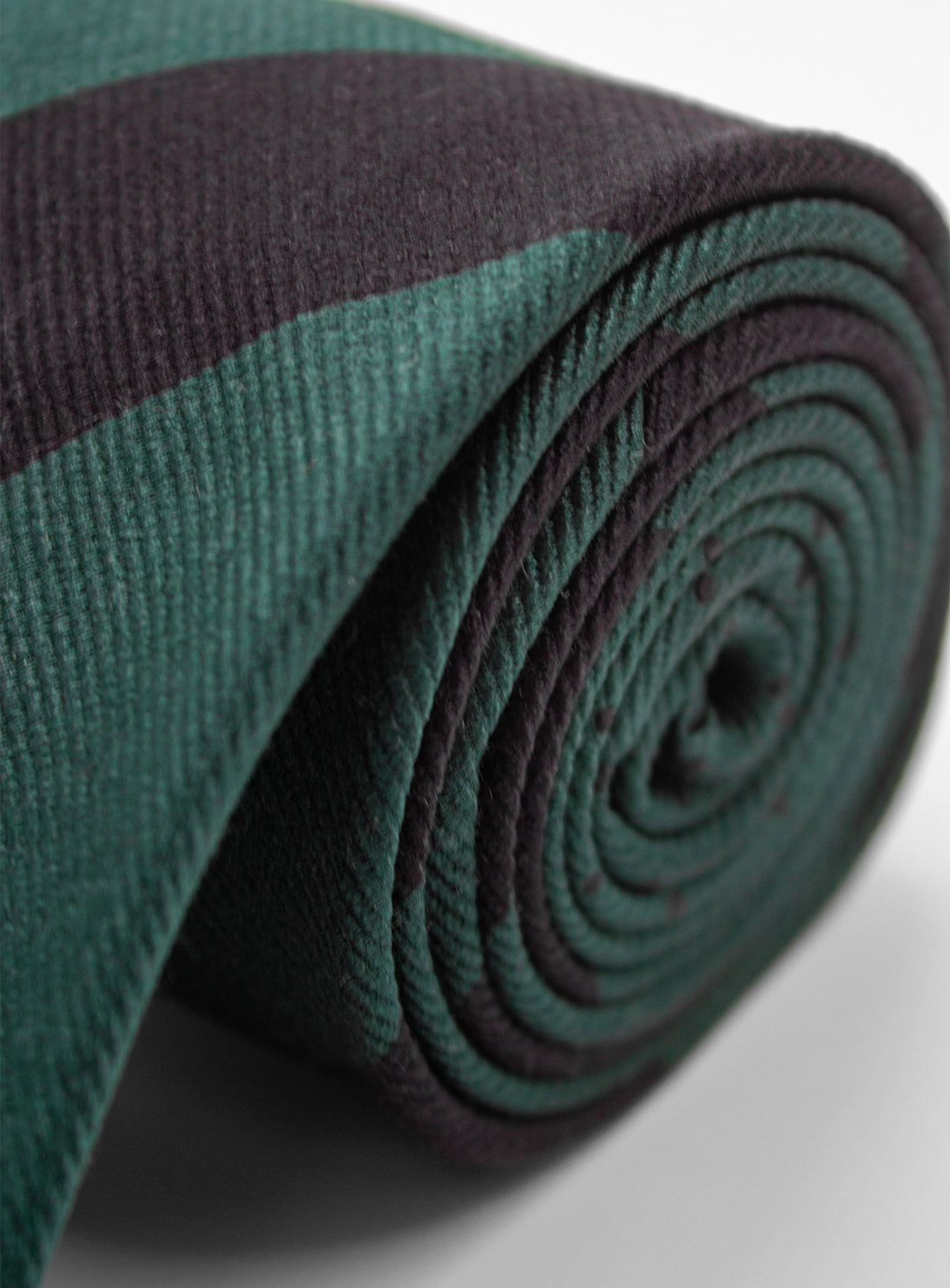 Rolled-up green and brown fabric mat on a light gray background