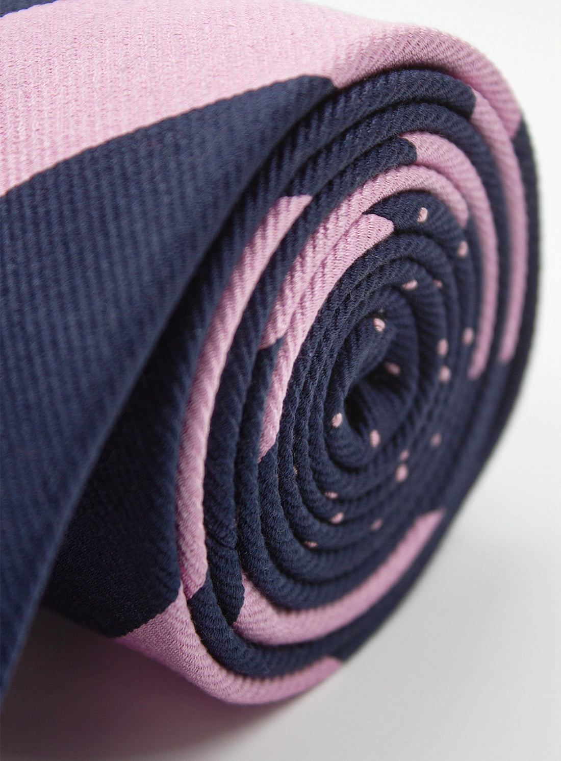 Roll of pink and navy fabric on a white background