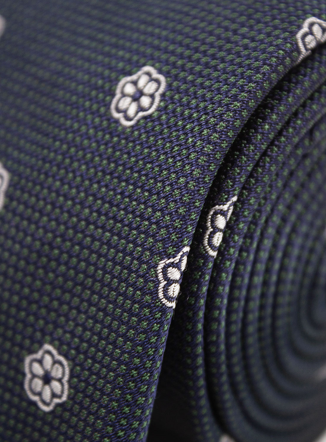 Close-up of the Bottinelli Notte Floral Navy Silk Tie rolled up
