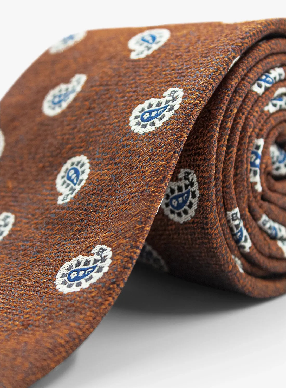 Brown tie with blue and white pattern on a light gray background