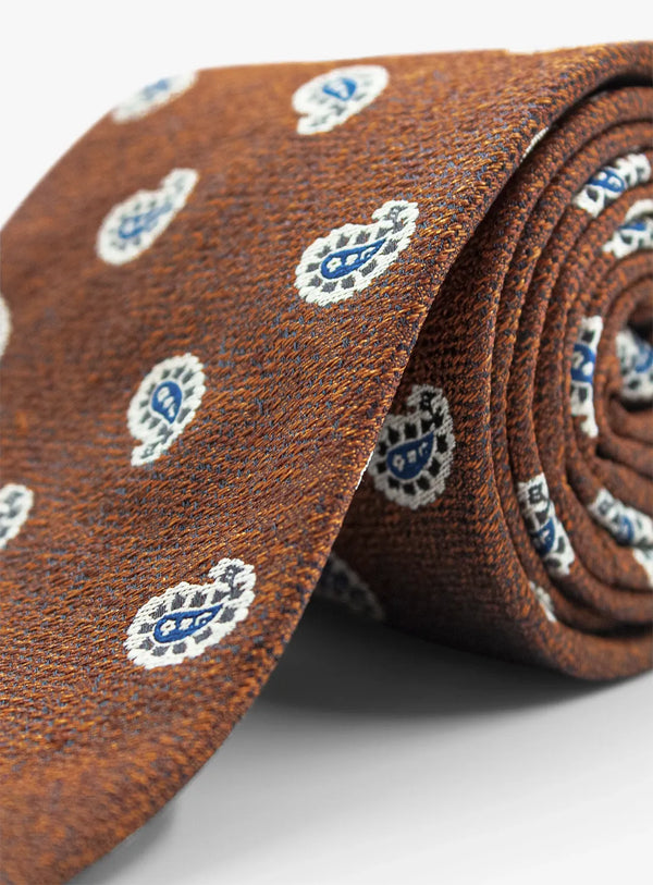 Brown tie with blue and white pattern on a light gray background