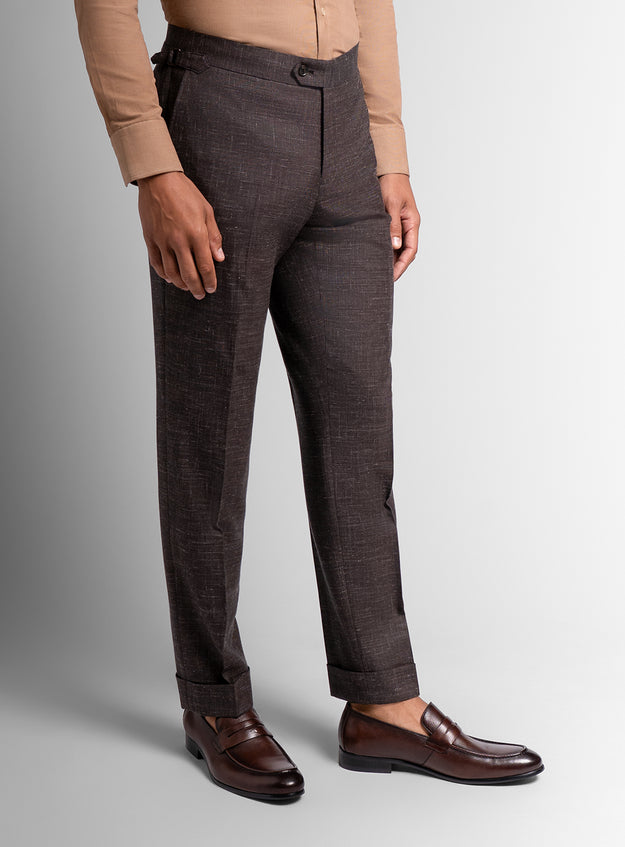 Brown trousers worn by a person on a gray background