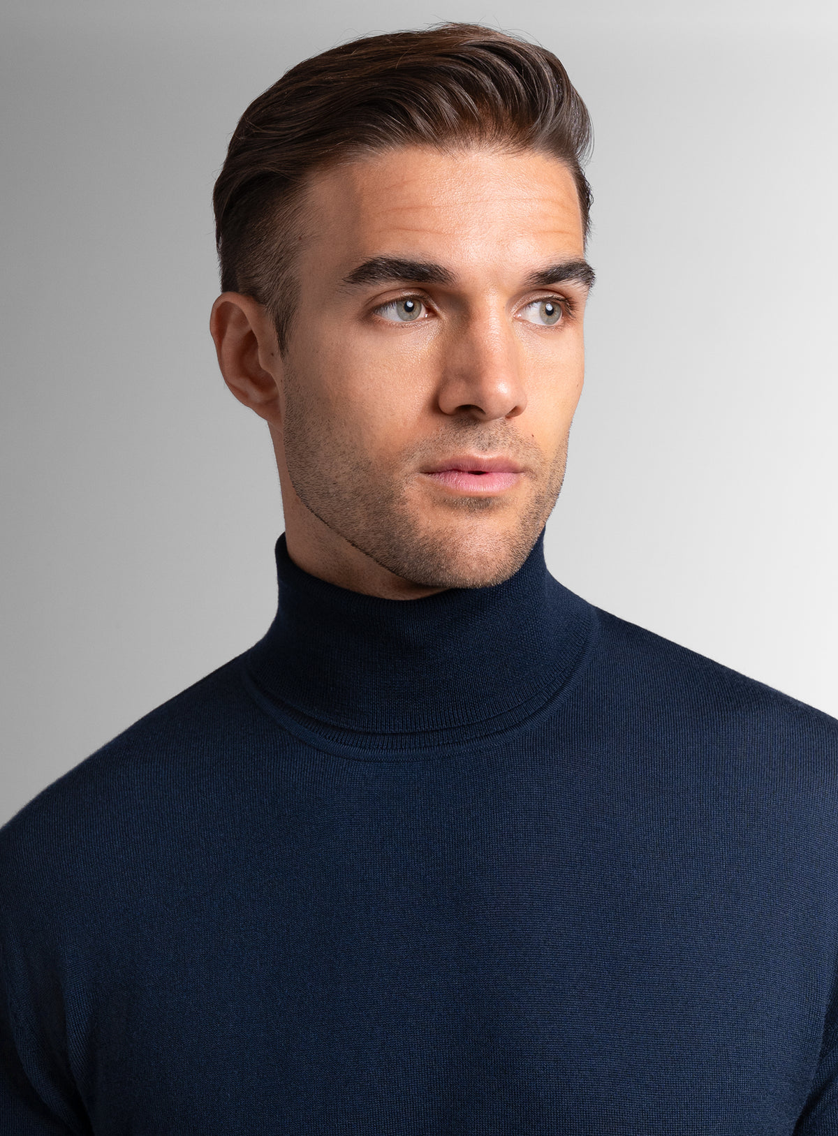 Close-up of a man wearing the Merino Wool Navy Turtleneck Knit