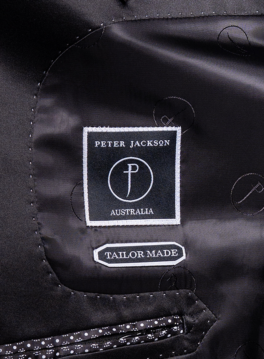 Close-up of a 'Peter Jackson Australia' tailor-made label on a black garment.
