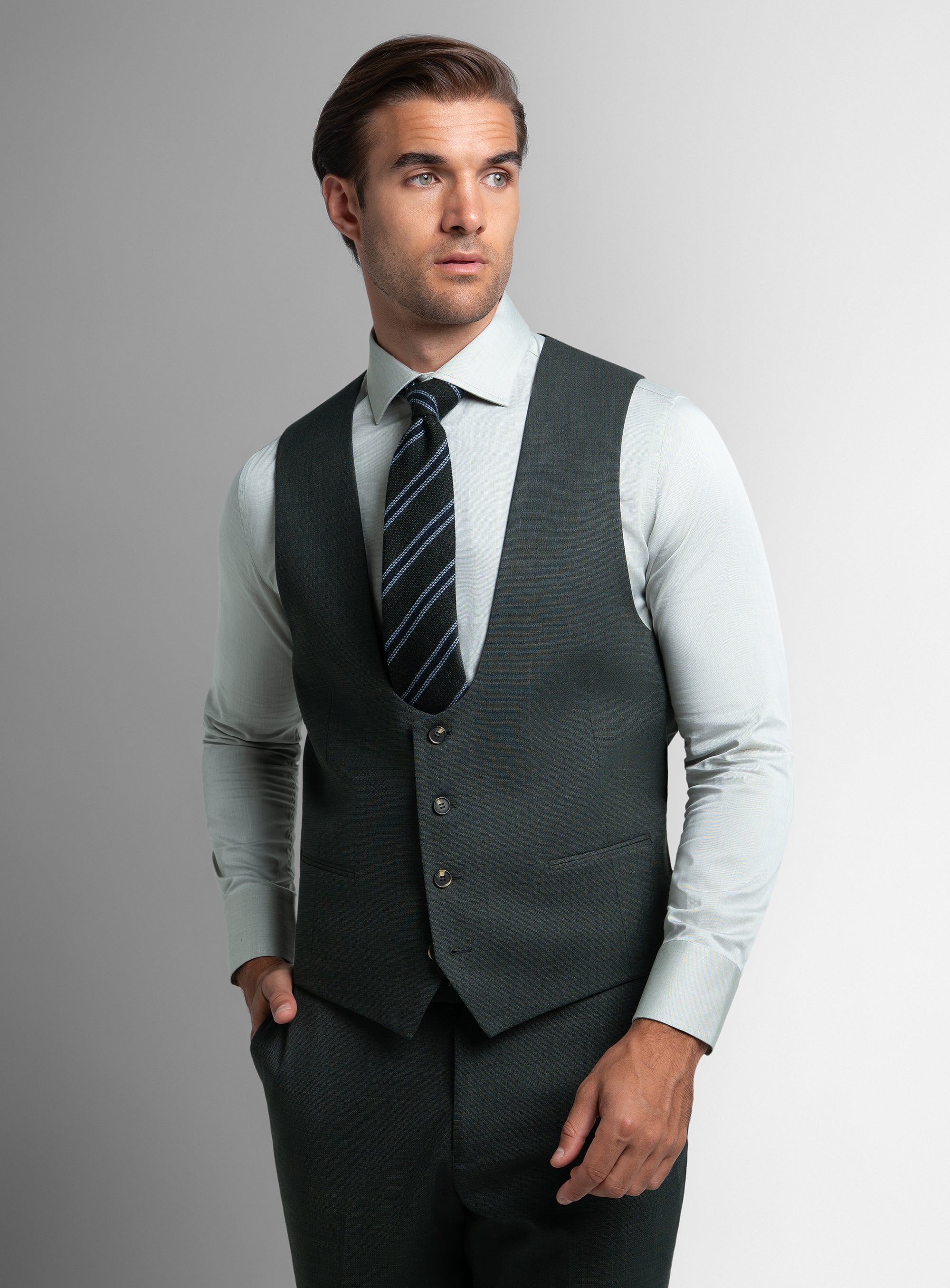 A man wearing the Gorlami Green Vest with his hand in his pocket