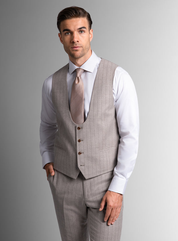 Man wearing a gray suit with a white shirt and tie on a gray background