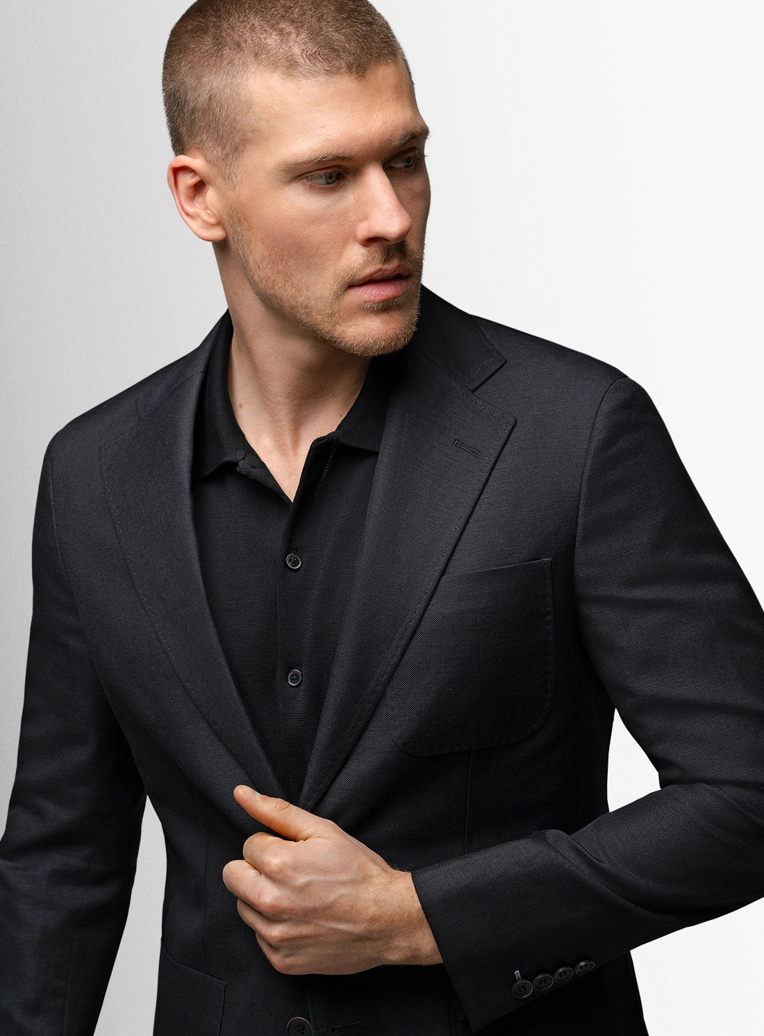 Man wearing a black suit against a gray background