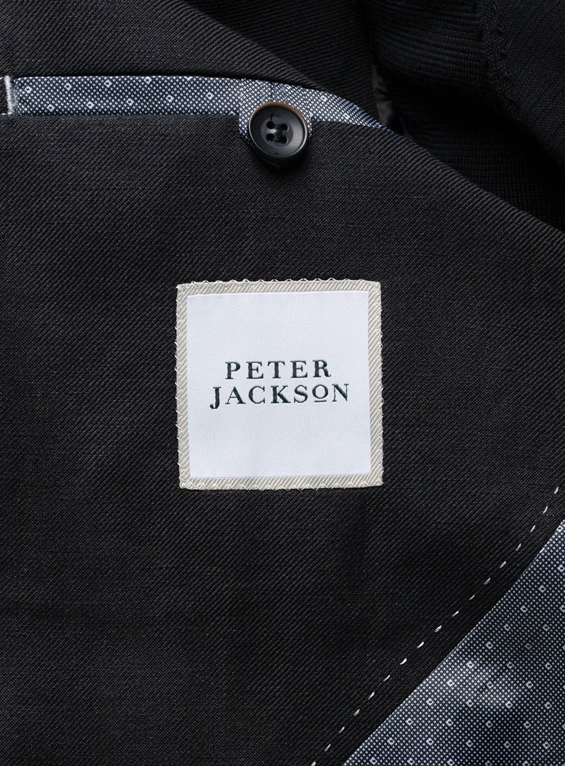 Close-up of a black jacket with a 'Peter Jackson' label.