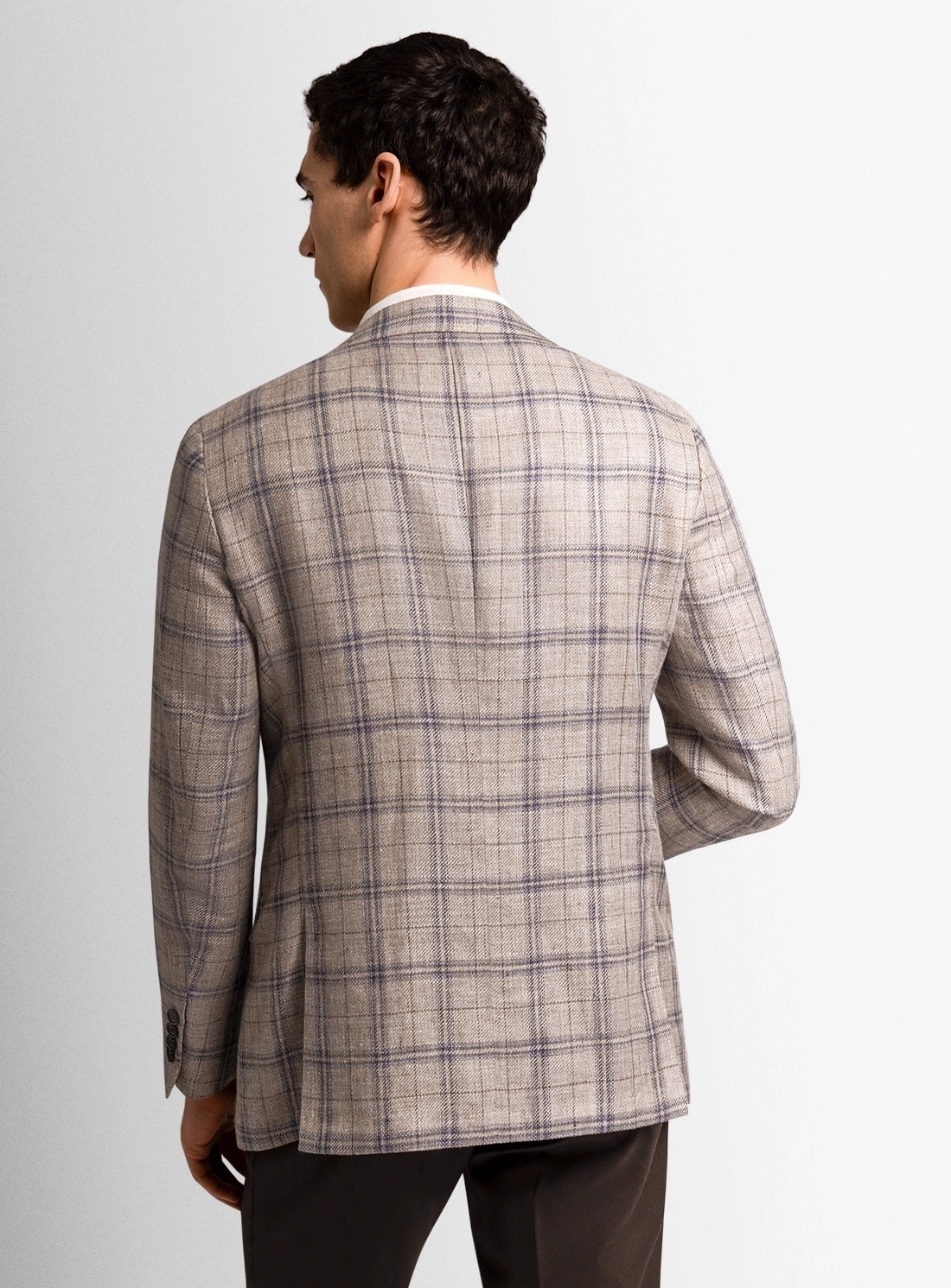 Man wearing a plaid blazer on a plain background