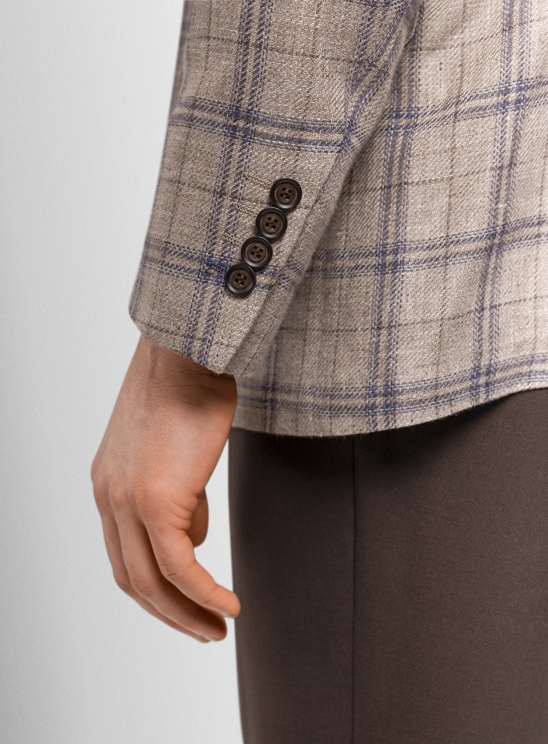 Close-up of a checkered jacket with buttons on a plain background