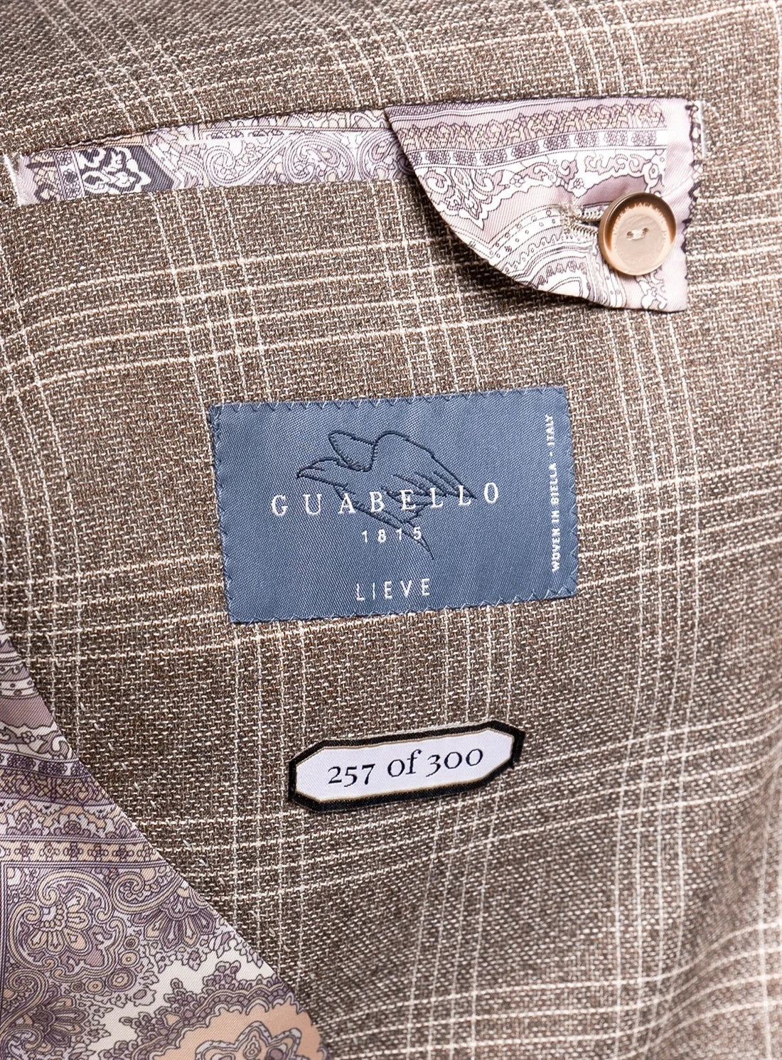 Close-up of a Guabello label on a textured fabric background