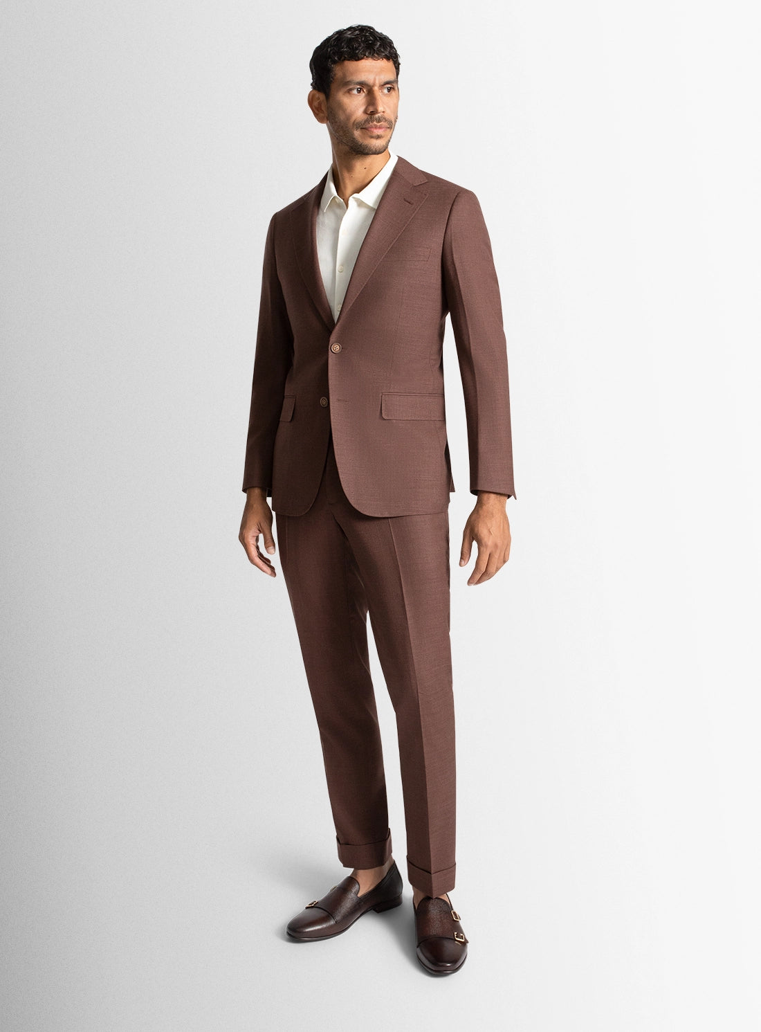 Man wearing a brown suit on a light gray background