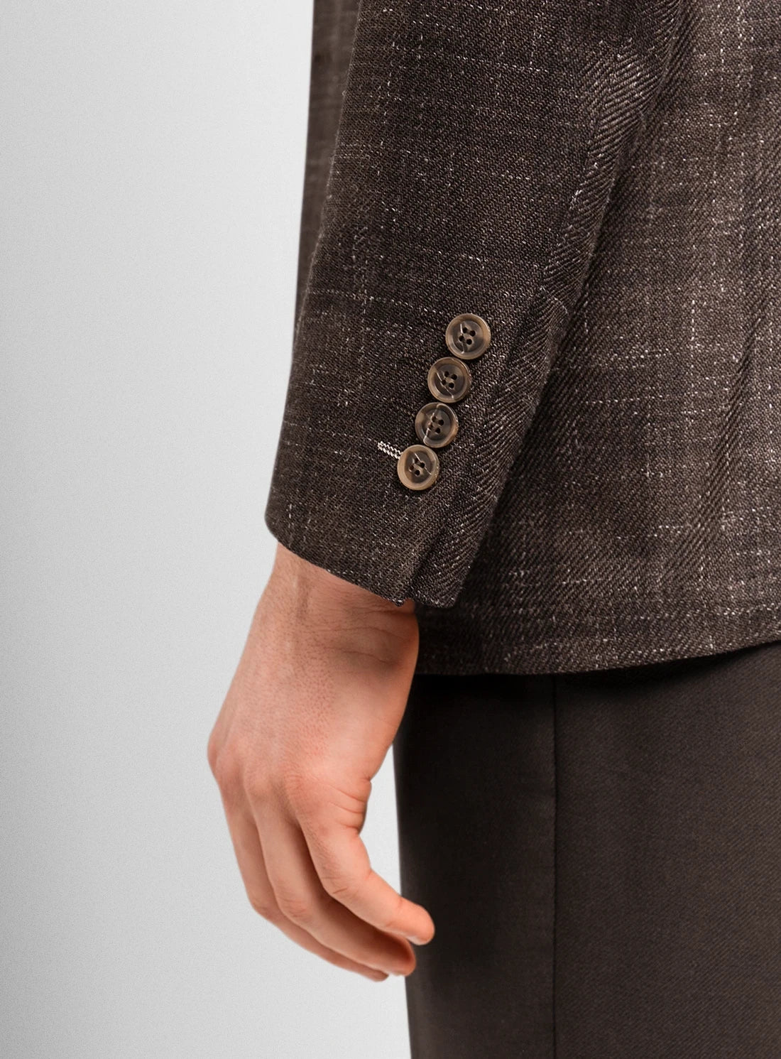 Brown textured blazer with buttons on a light gray background