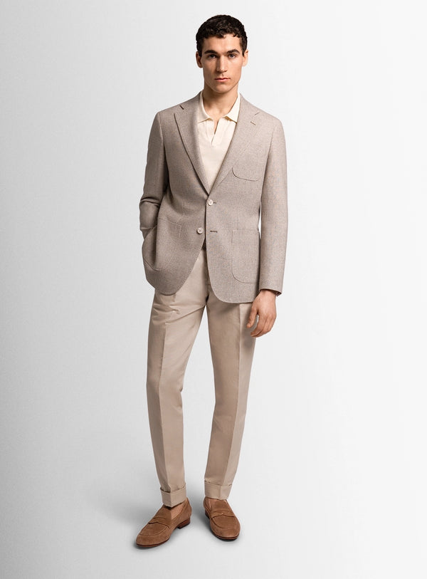 Man wearing a beige suit with a white shirt on a light gray background