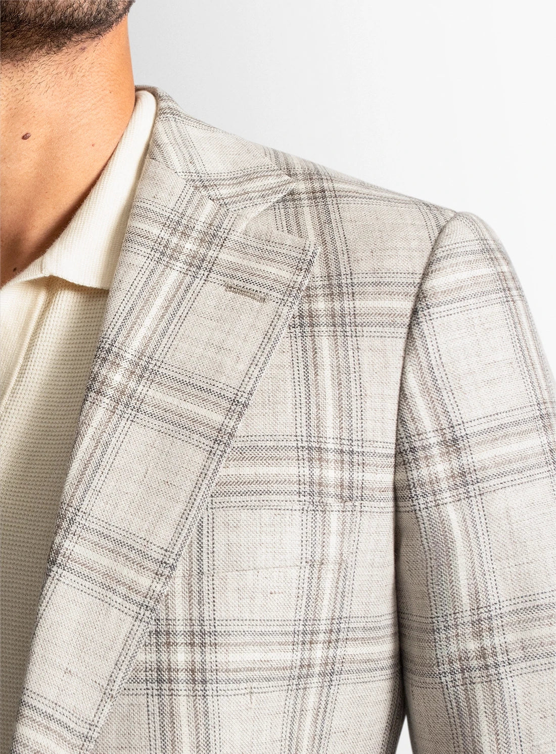 Plaid pattern on a suit jacket with a neutral background