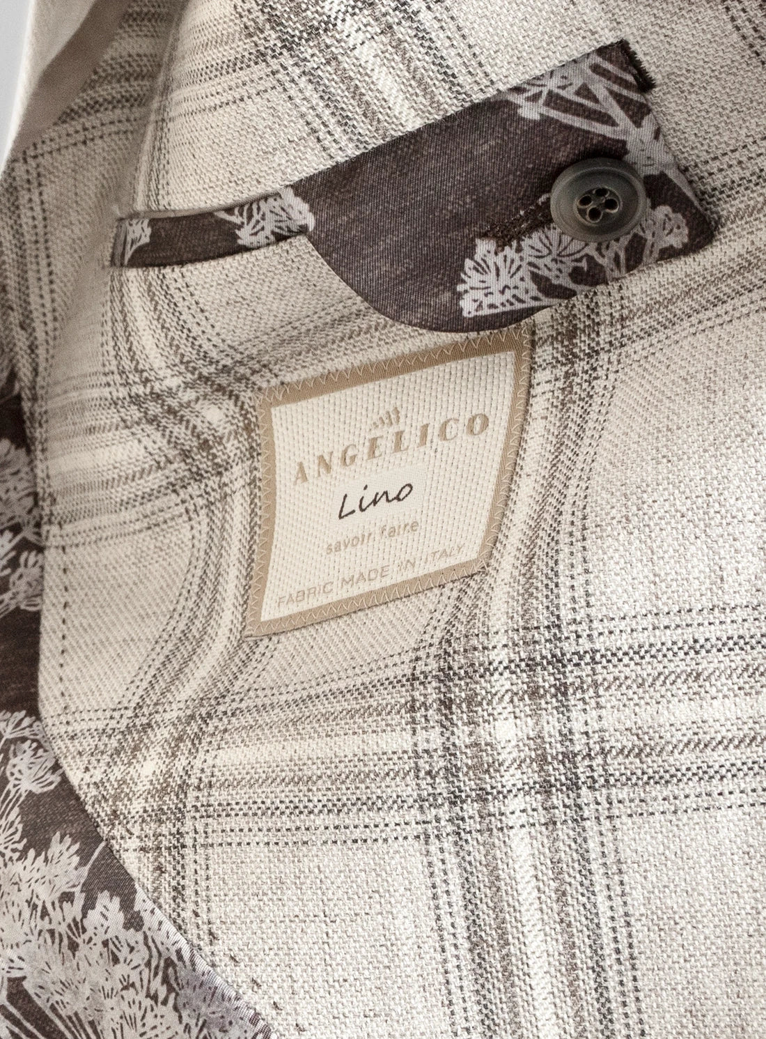 Close-up of a plaid fabric with a brand label on a textured background