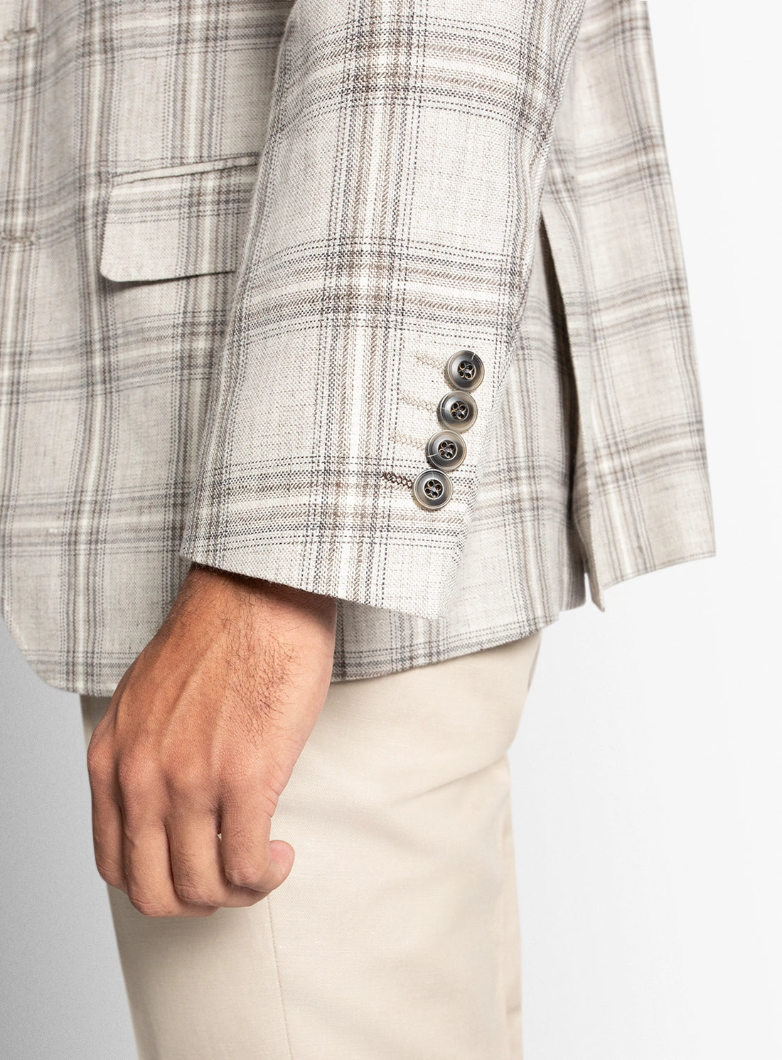 Close-up of a checkered blazer with buttons on a neutral background