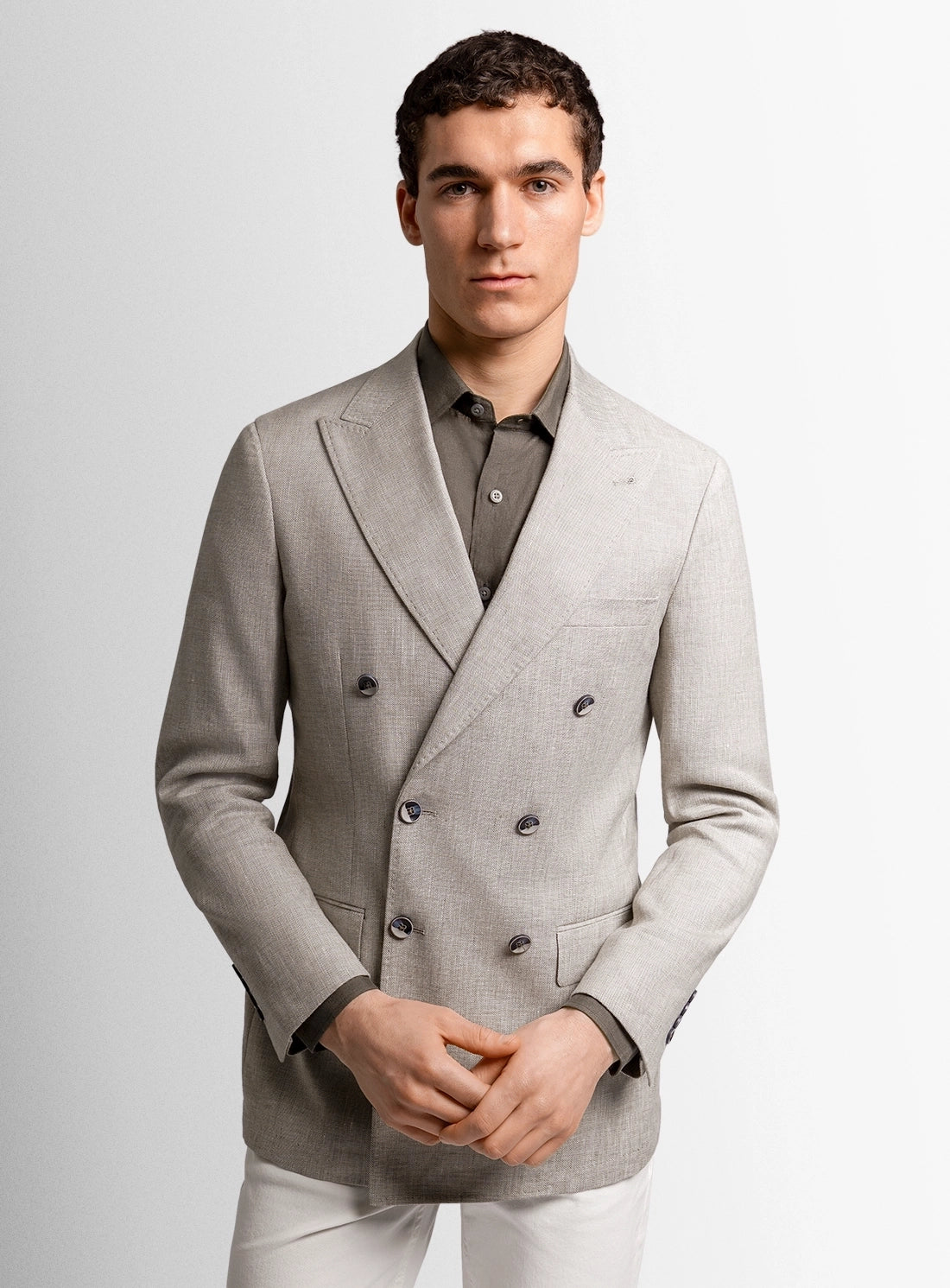 Man wearing a gray double-breasted suit jacket on a light gray background