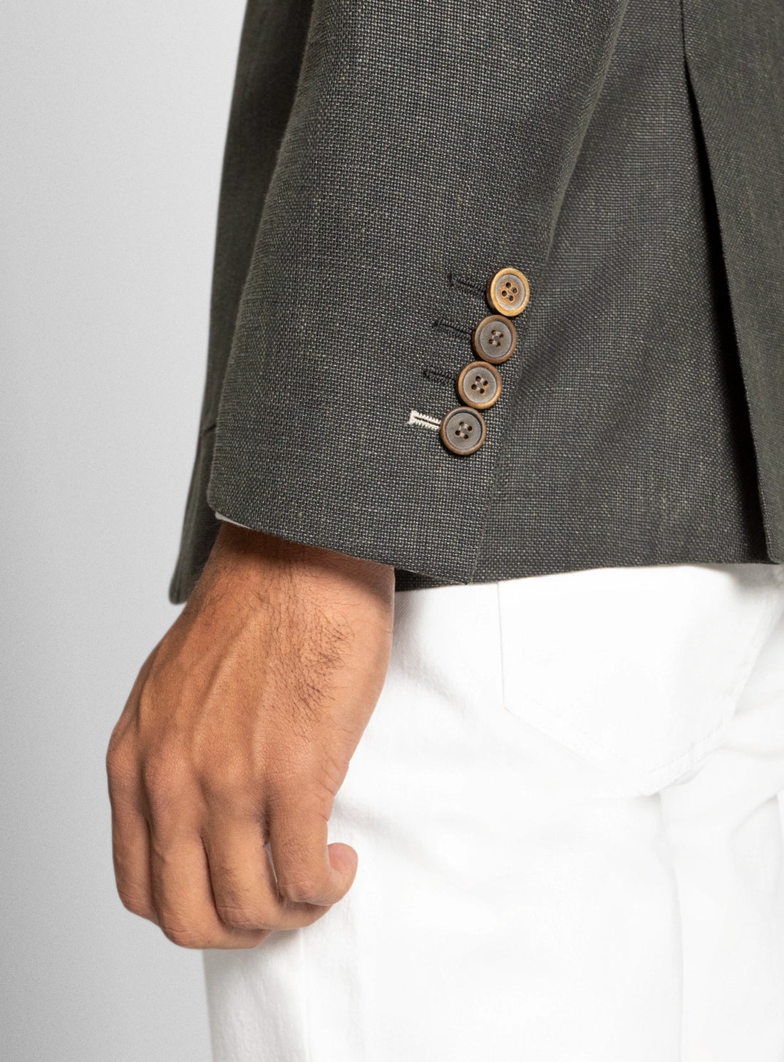 Gray suit jacket with brown buttons on a plain background