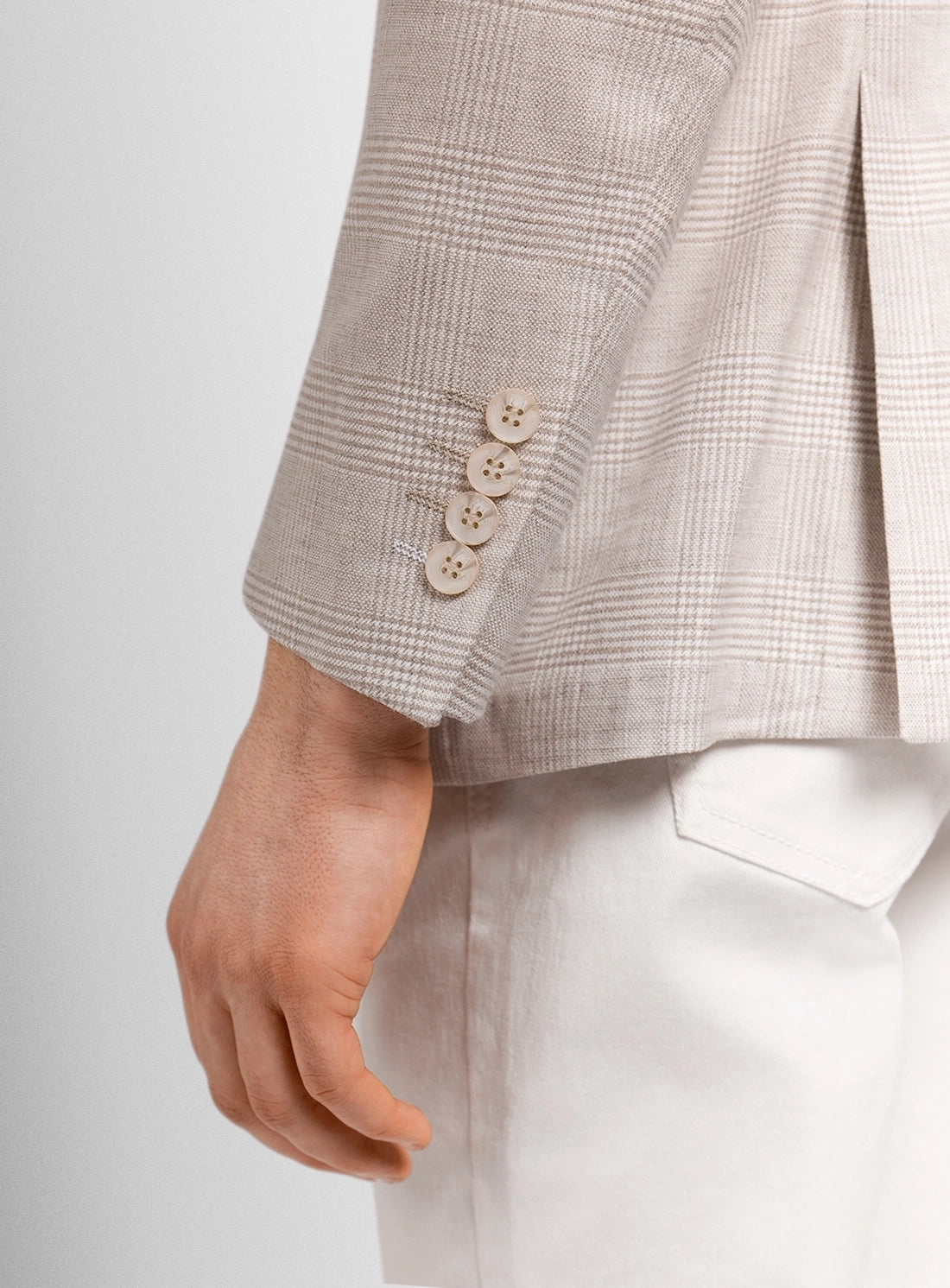 Close-up of a checkered blazer with buttons on a plain background