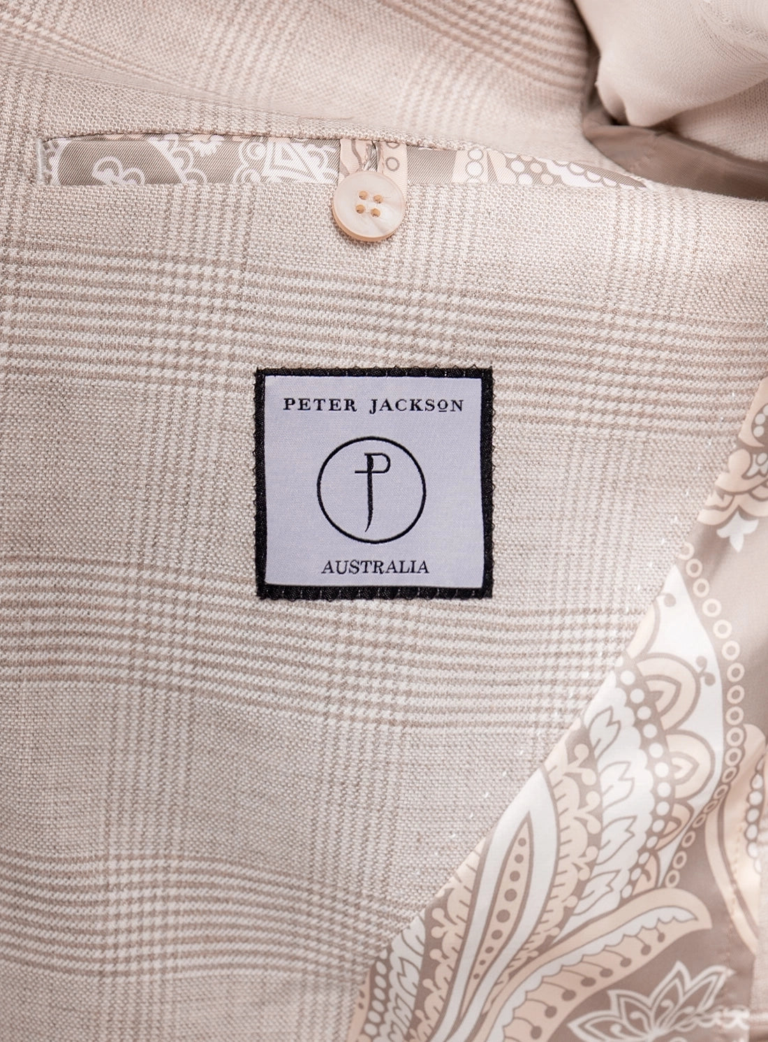 Close-up of a 'Peter Jackson Australia' label on a textured fabric background.