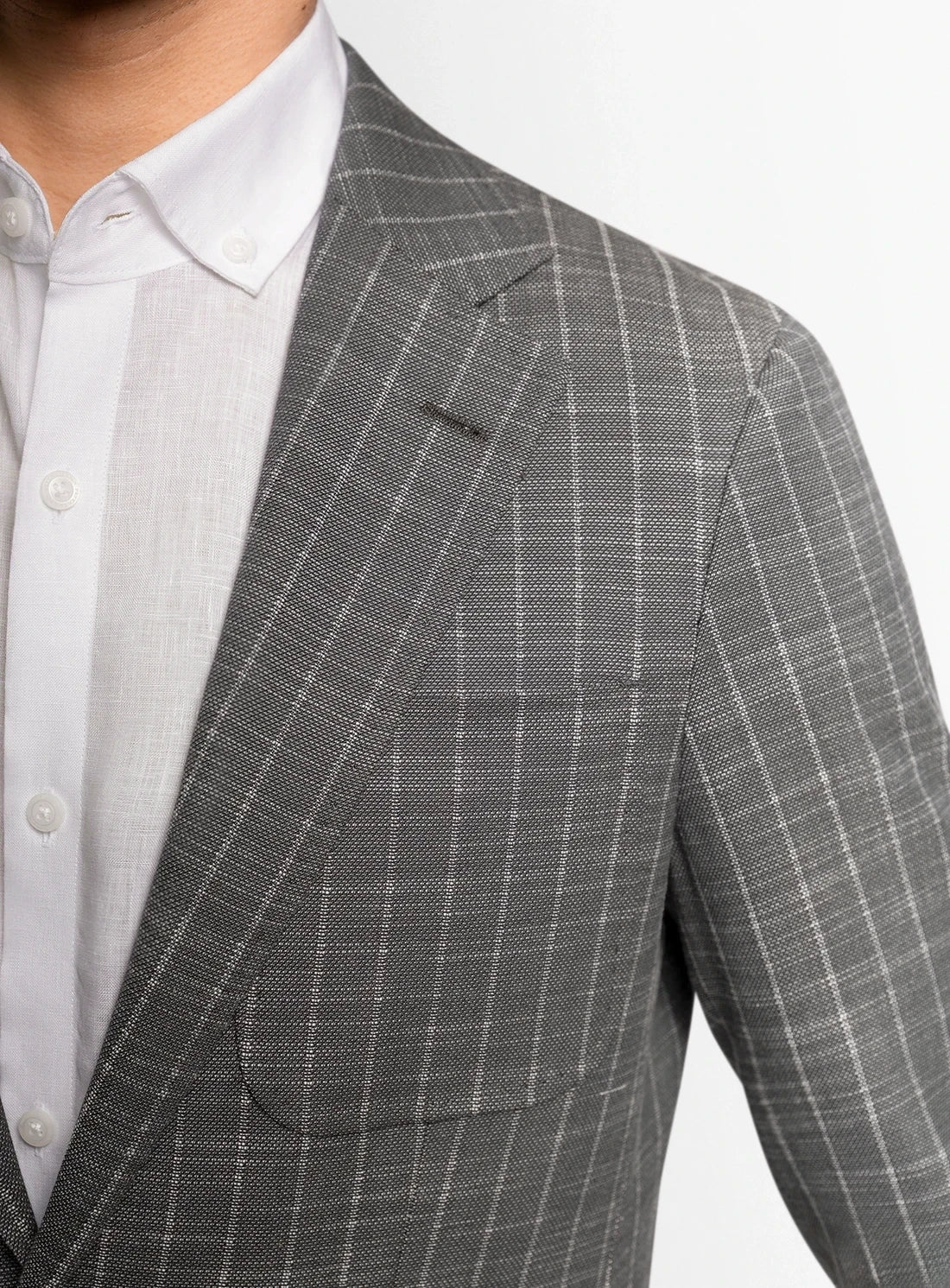 Gray checkered suit jacket worn by a person on a white background