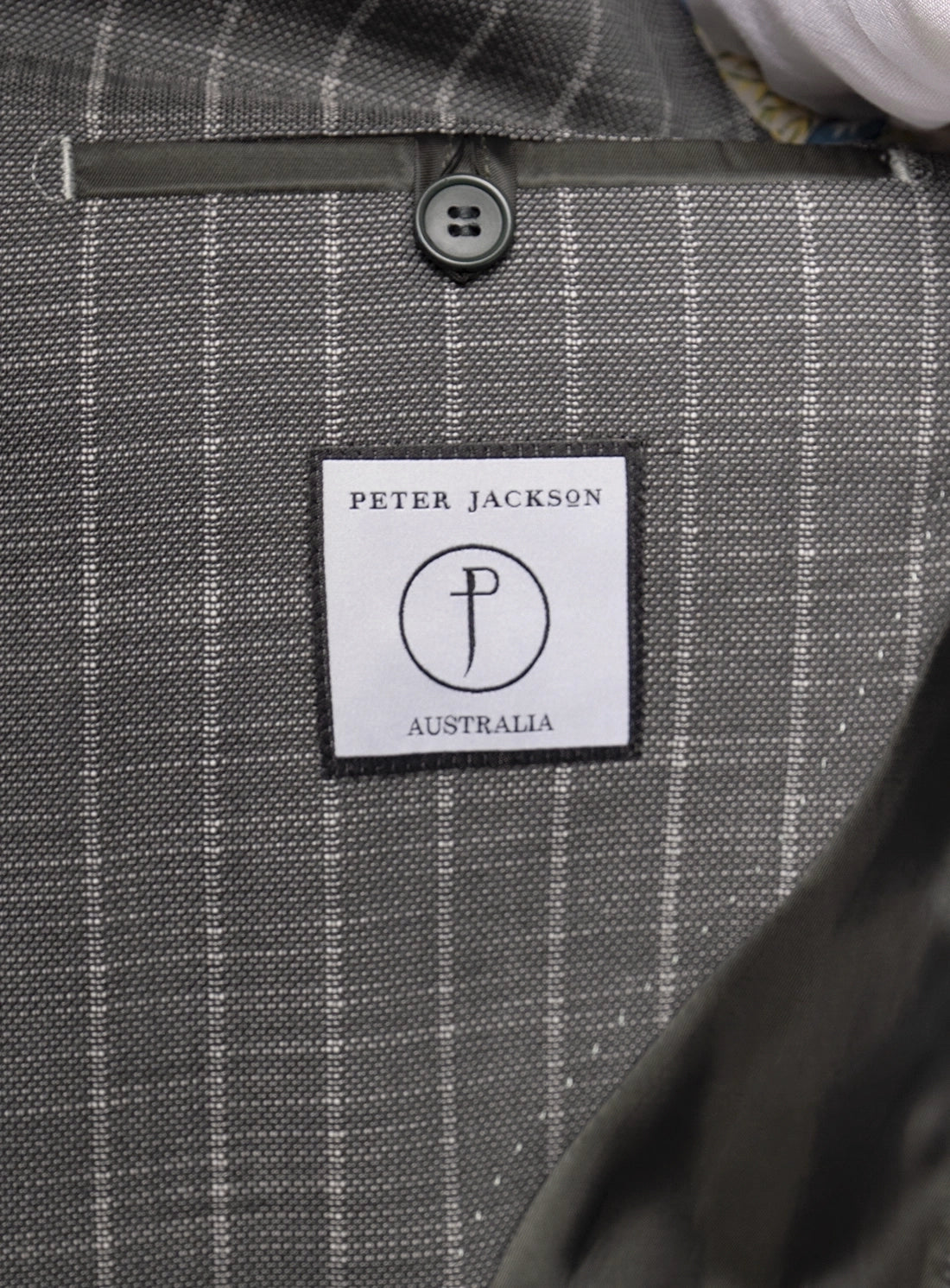 Close-up of a gray checkered fabric with a Peter Jackson Australia label.