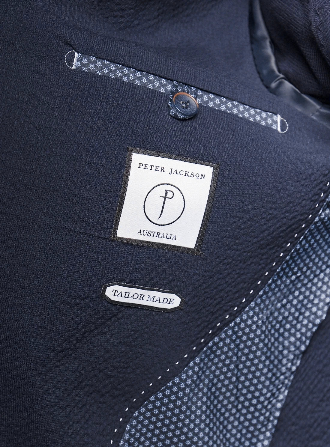 Navy fabric with a Peter Jackson Australia label and 'Tailor Made' tag.