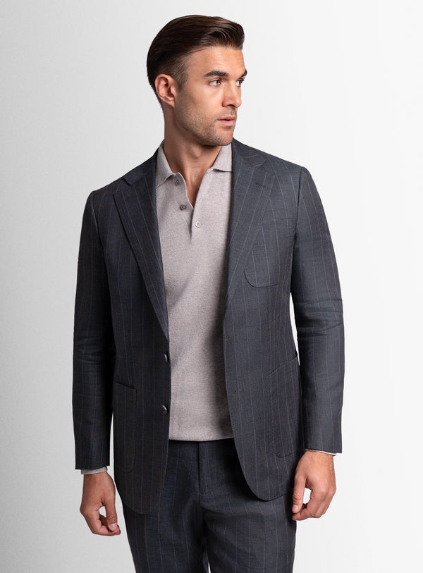 Man wearing a gray pinstripe suit and light gray shirt on a white background