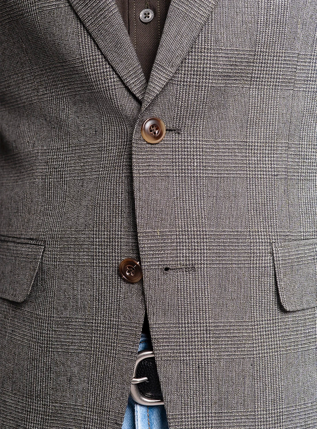 Close-up of a gray checkered blazer with two buttons and a belt.