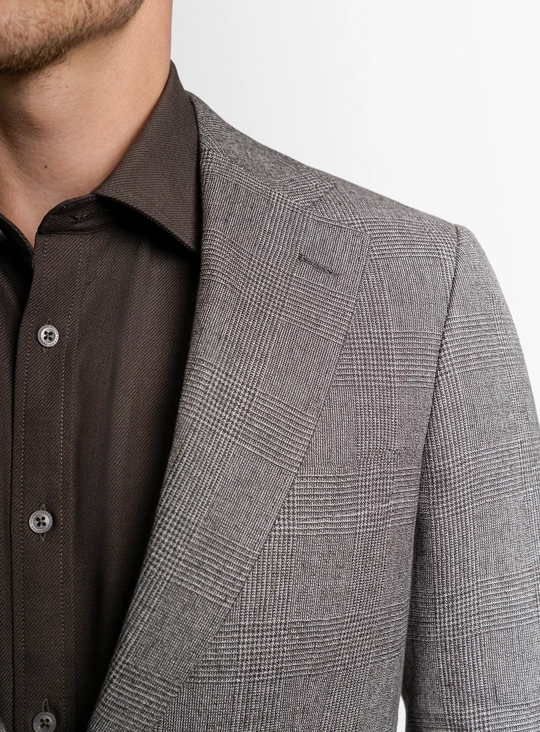 Gray checkered blazer over a brown shirt on a white background