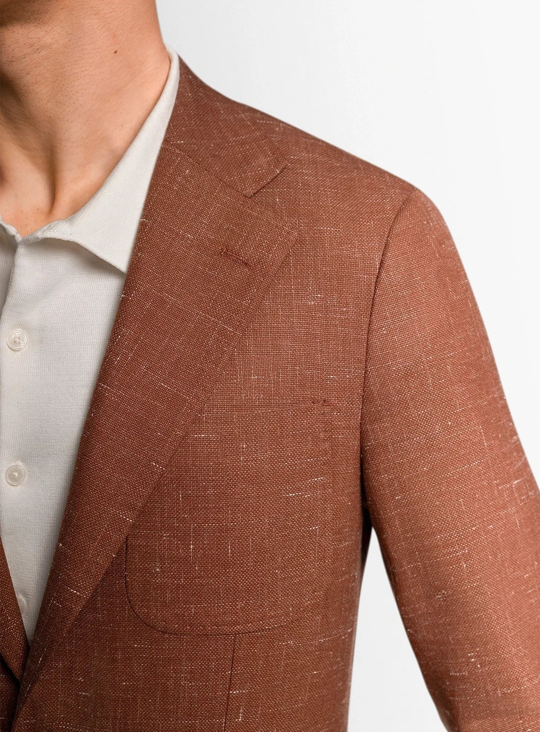 Brown suit jacket worn by a person on a light gray background