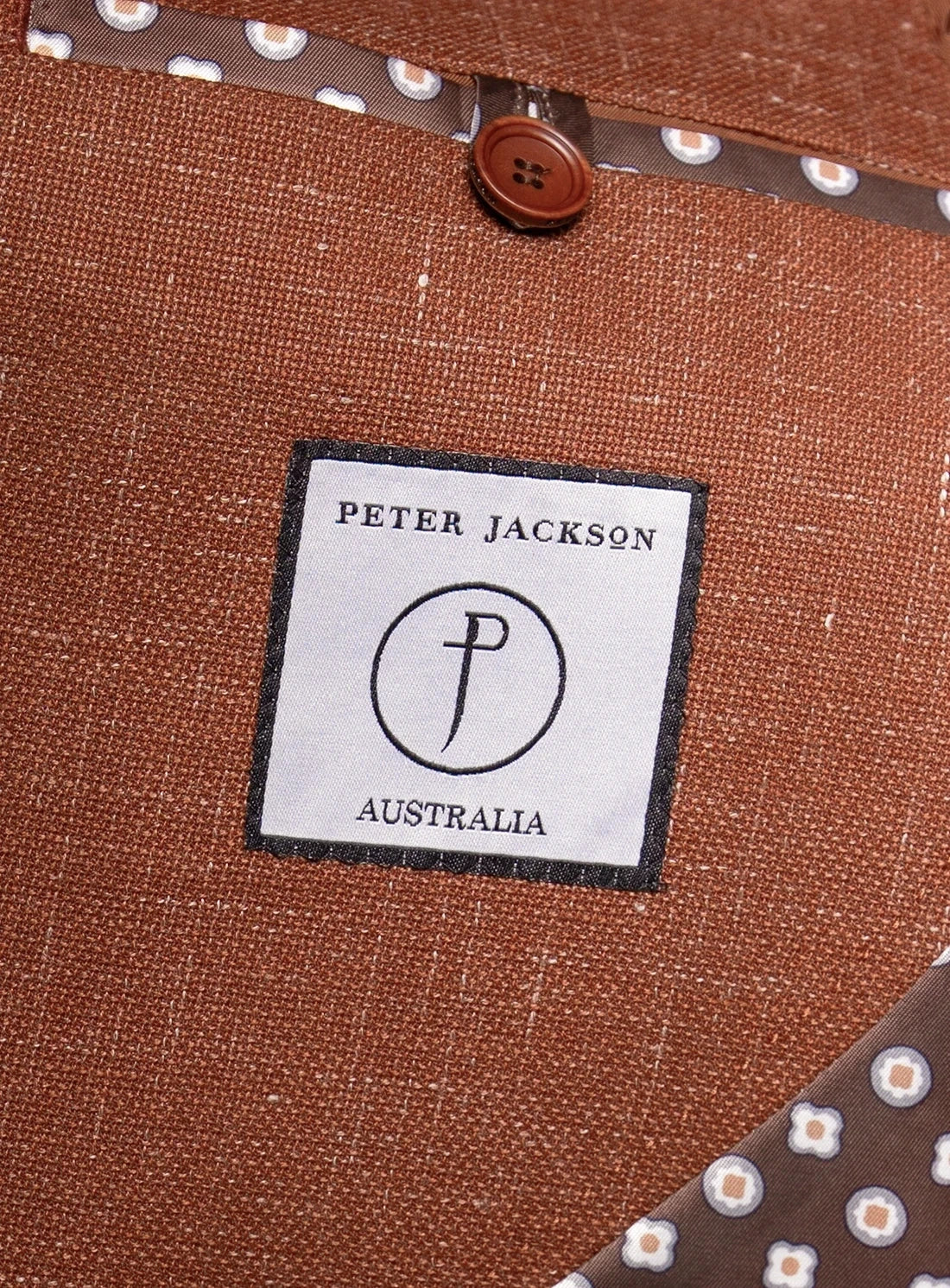 Close-up of a 'Peter Jackson Australia' label on brown fabric.