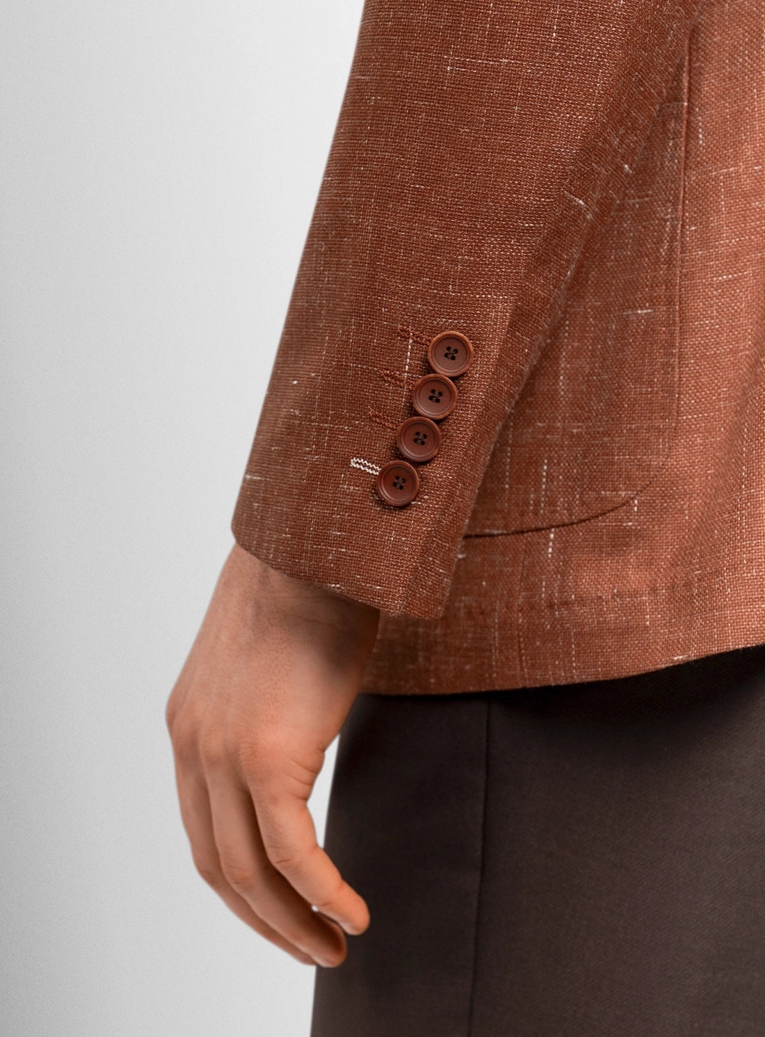 Brown textured blazer with buttons on a light gray background