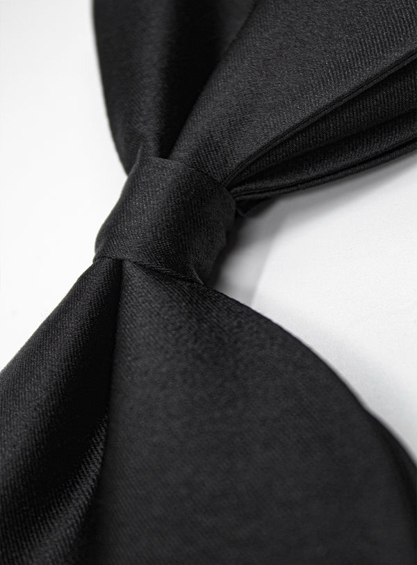 Close-up of a black tie knot on a white background