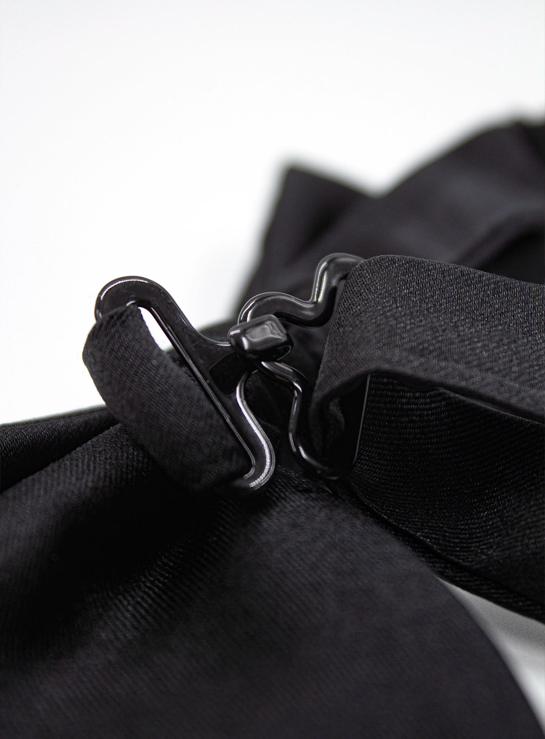 Close-up of a black bag with a strap and buckle on a white background
